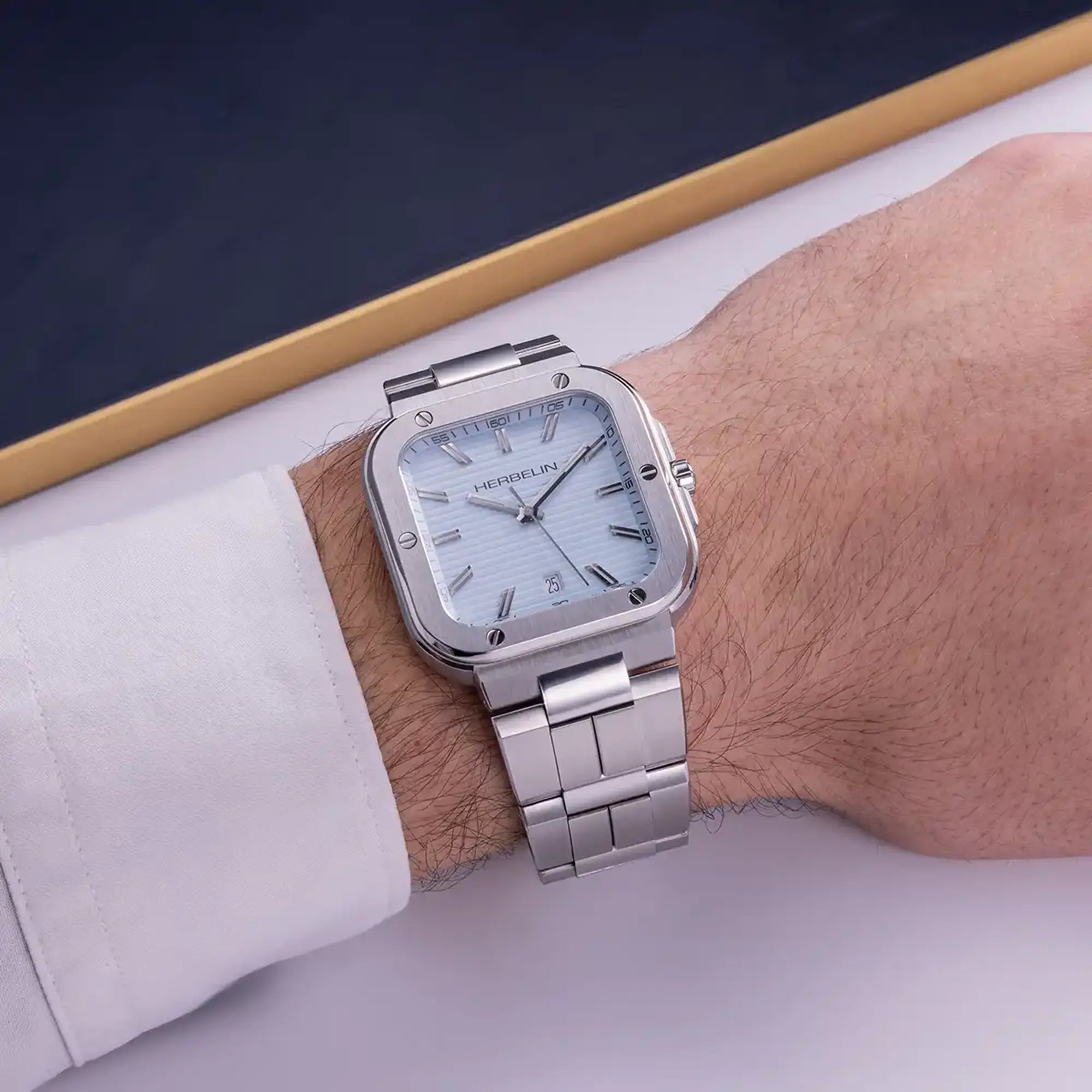 Au poignet masculin, cadran bleu arctique et bracelet acier visibles