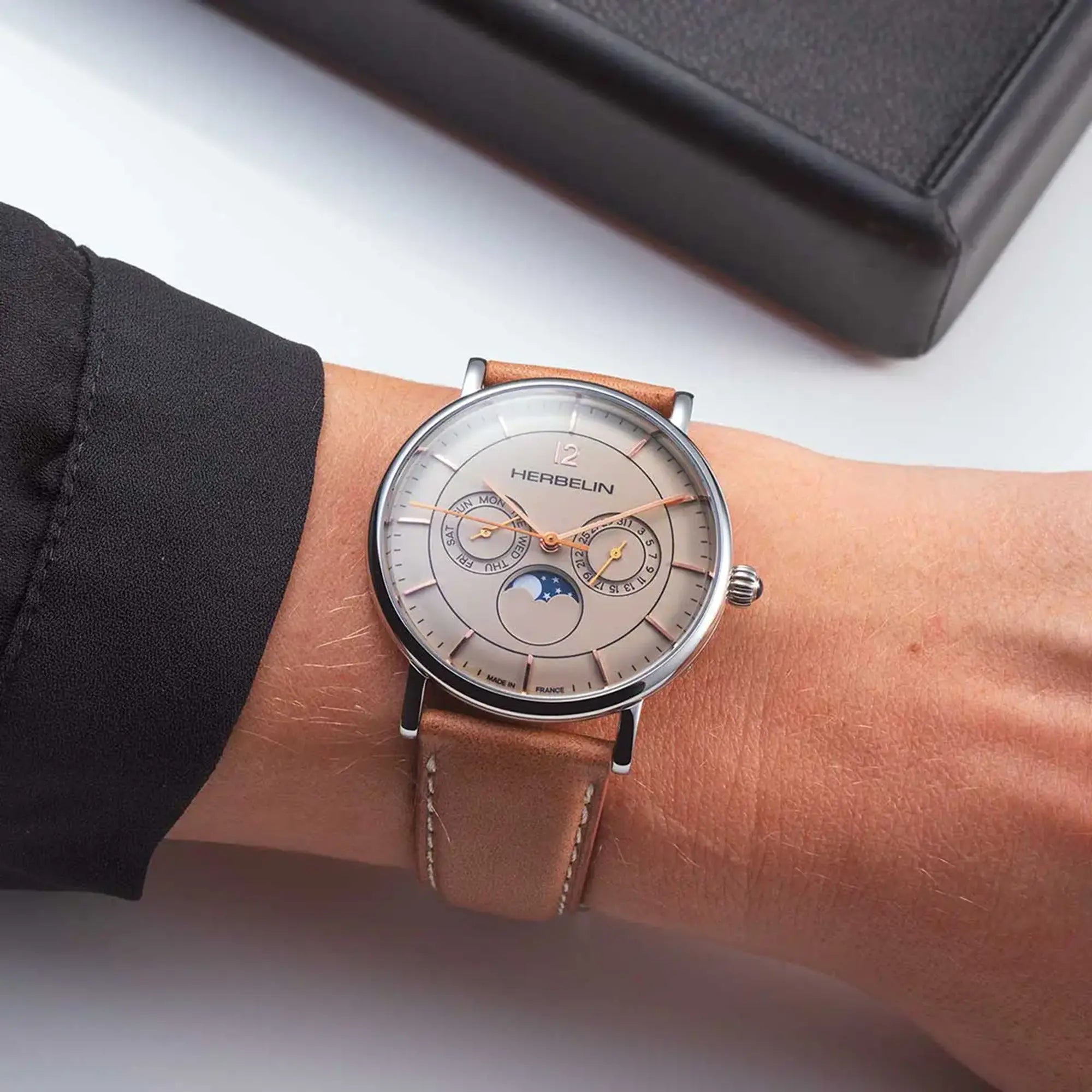 Au poignet masculin, cadran coquille d'œuf et bracelet cuir visibles