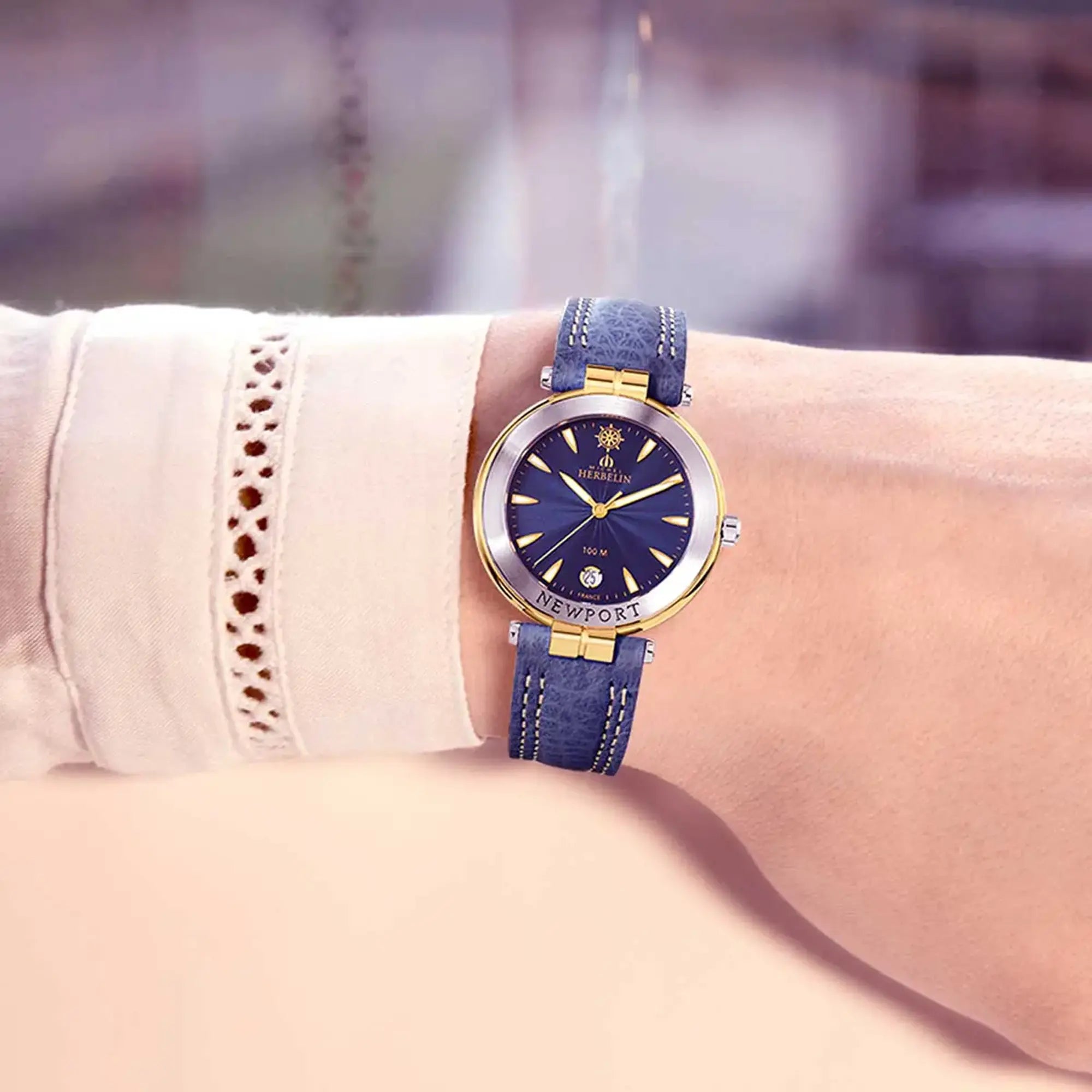 Au poignet féminin, cadran bleu guilloché et bracelet cuir visibles