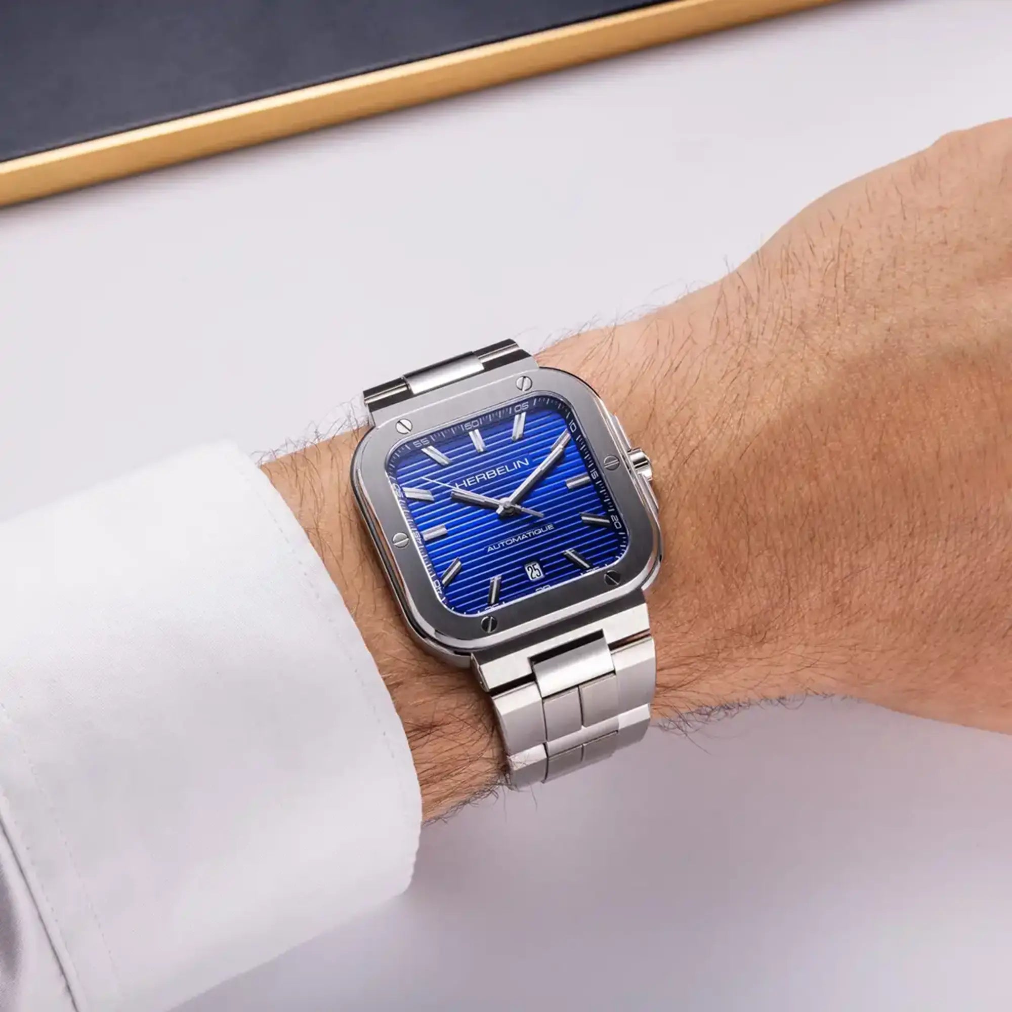 Au poignet masculin, cadran bleu cobalt et bracelet acier visibles