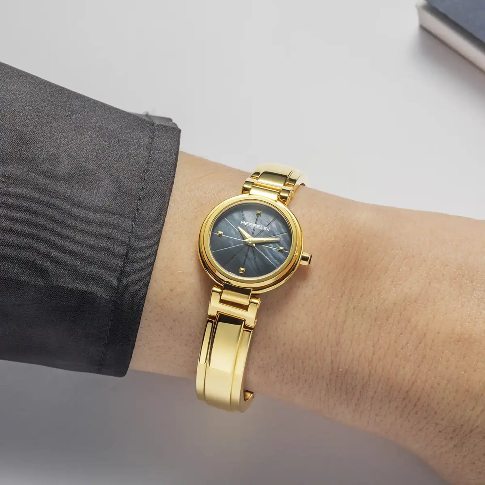 Au poignet féminin, cadran nacre blanche et bracelet acier bicolore visibles