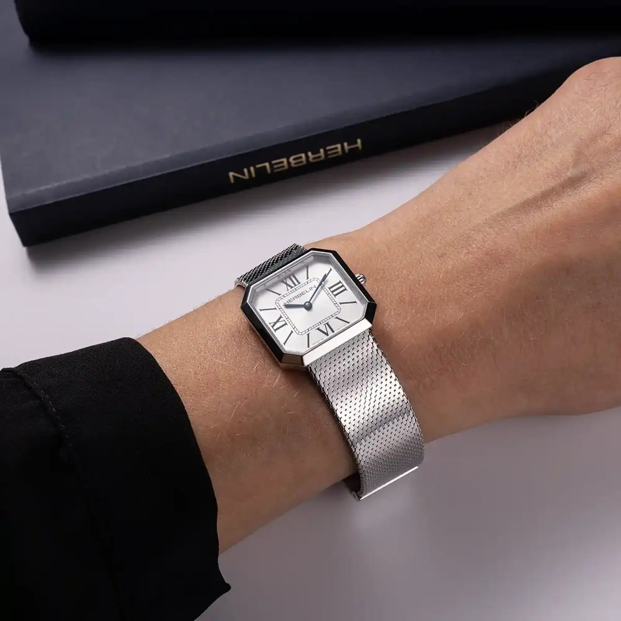 Au poignet féminin, cadran argent blanc et bracelet acier visibles