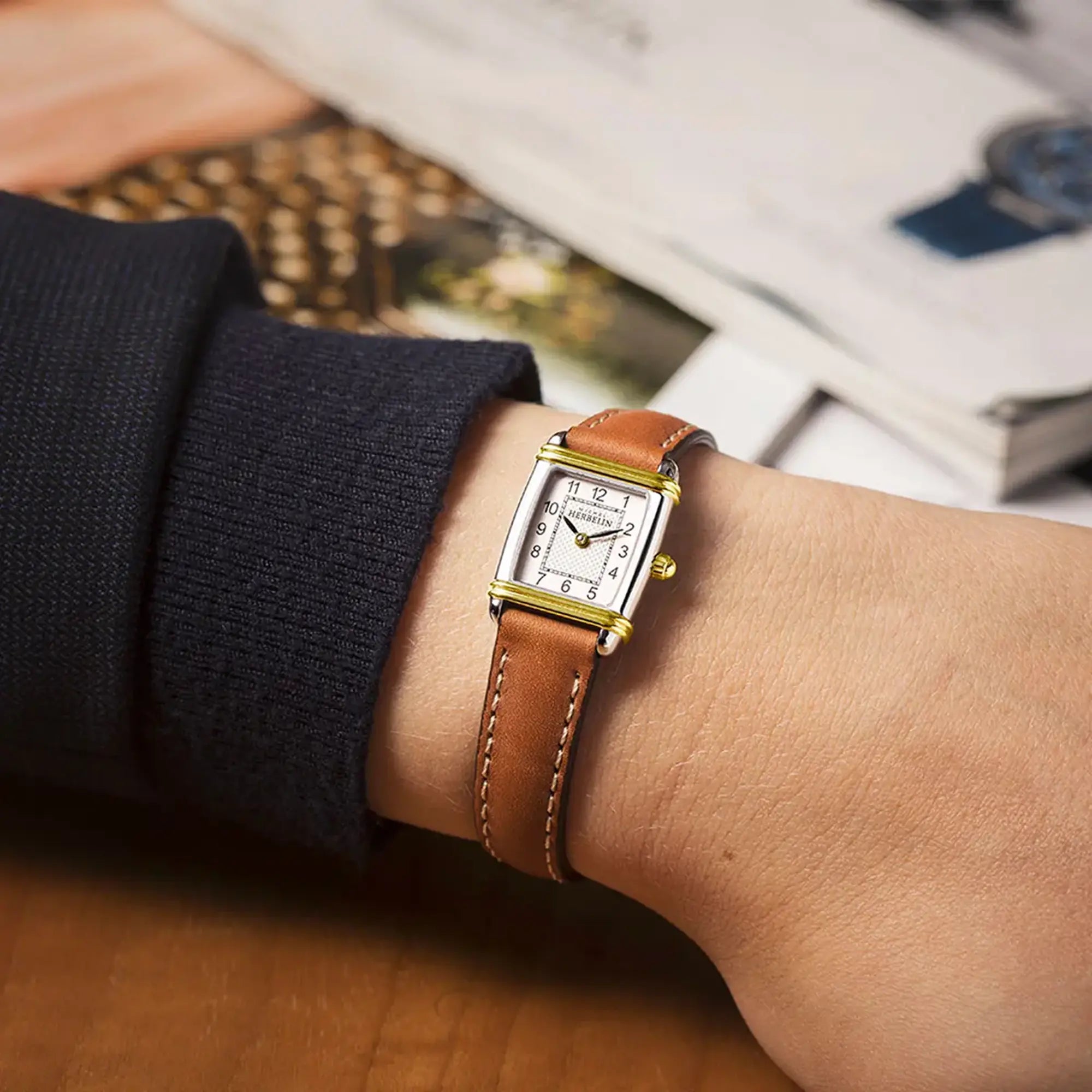 Au poignet féminin, cadran argent guilloché et bracelet cuir visibles