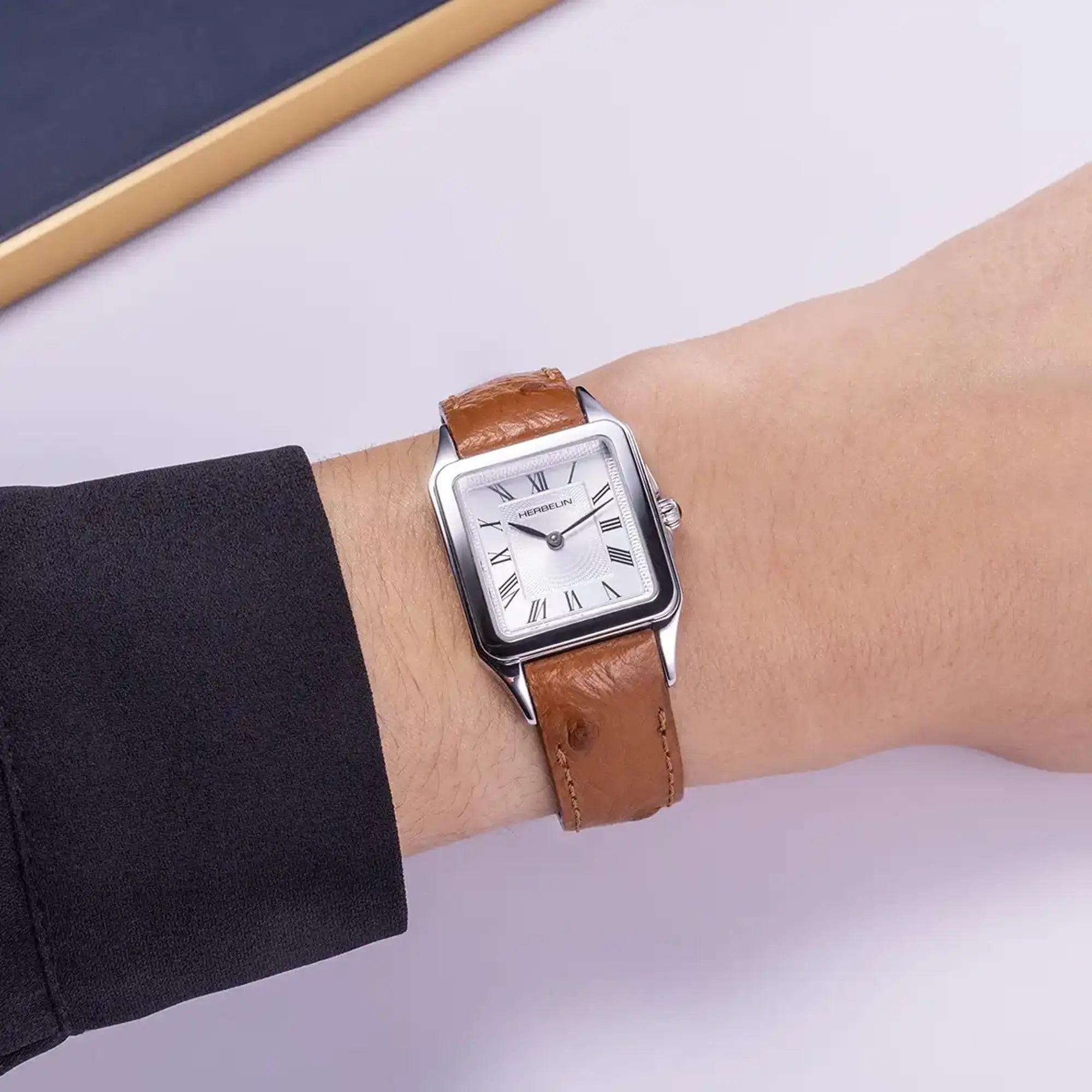 Au poignet féminin, cadran argent guilloché et bracelet cuir visibles
