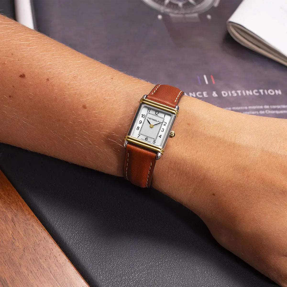Til det feminine håndled, urskive i sølv og kamelbrunt læderarmbånd ses