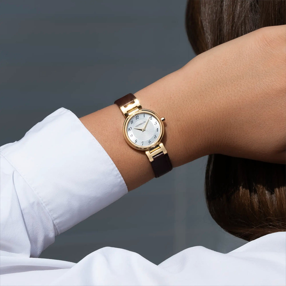 Autre vue au poignet féminin, cadran argent blanc guilloché et bracelet cuir visibles