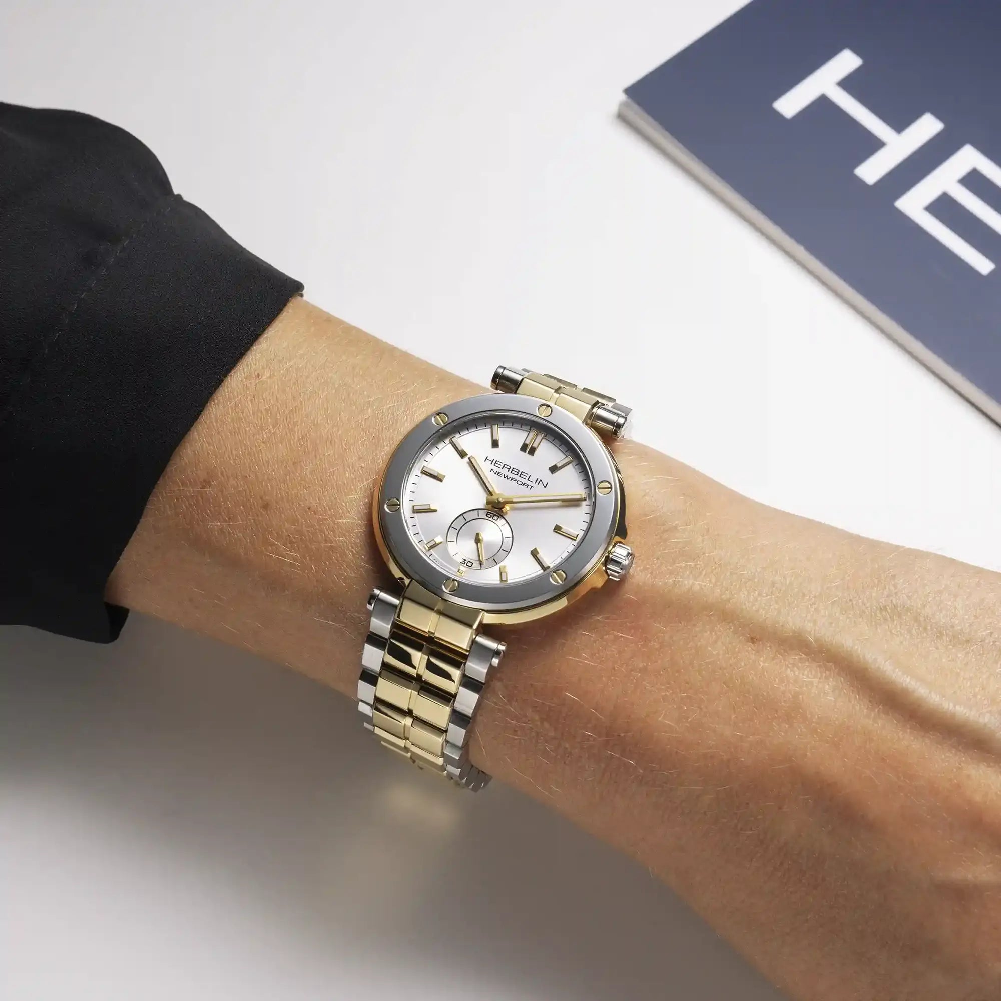 Au poignet féminin, cadran argent blanc et bracelet acier bicolore visibles