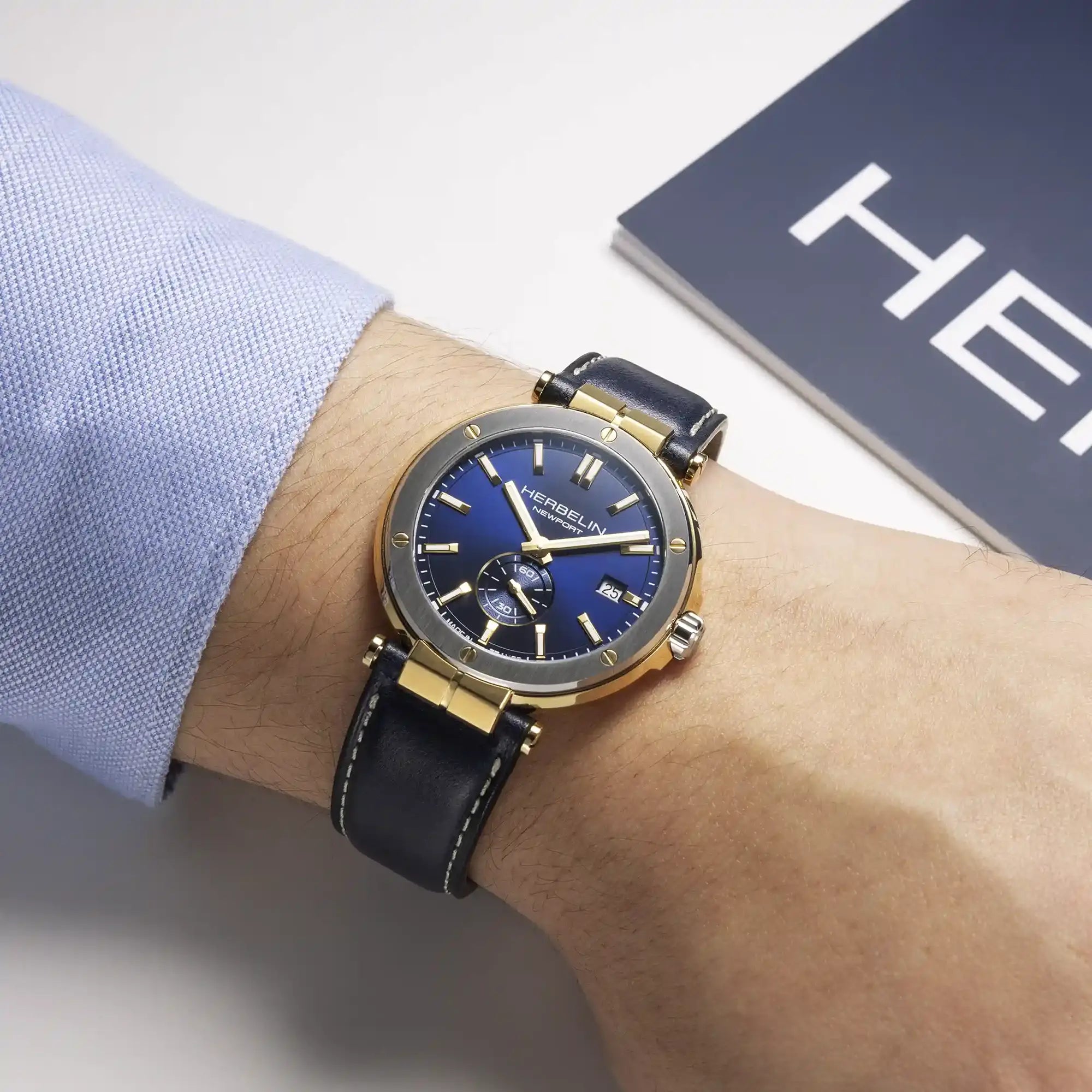 Au poignet masculin, cadran bleu et bracelet cuir visibles