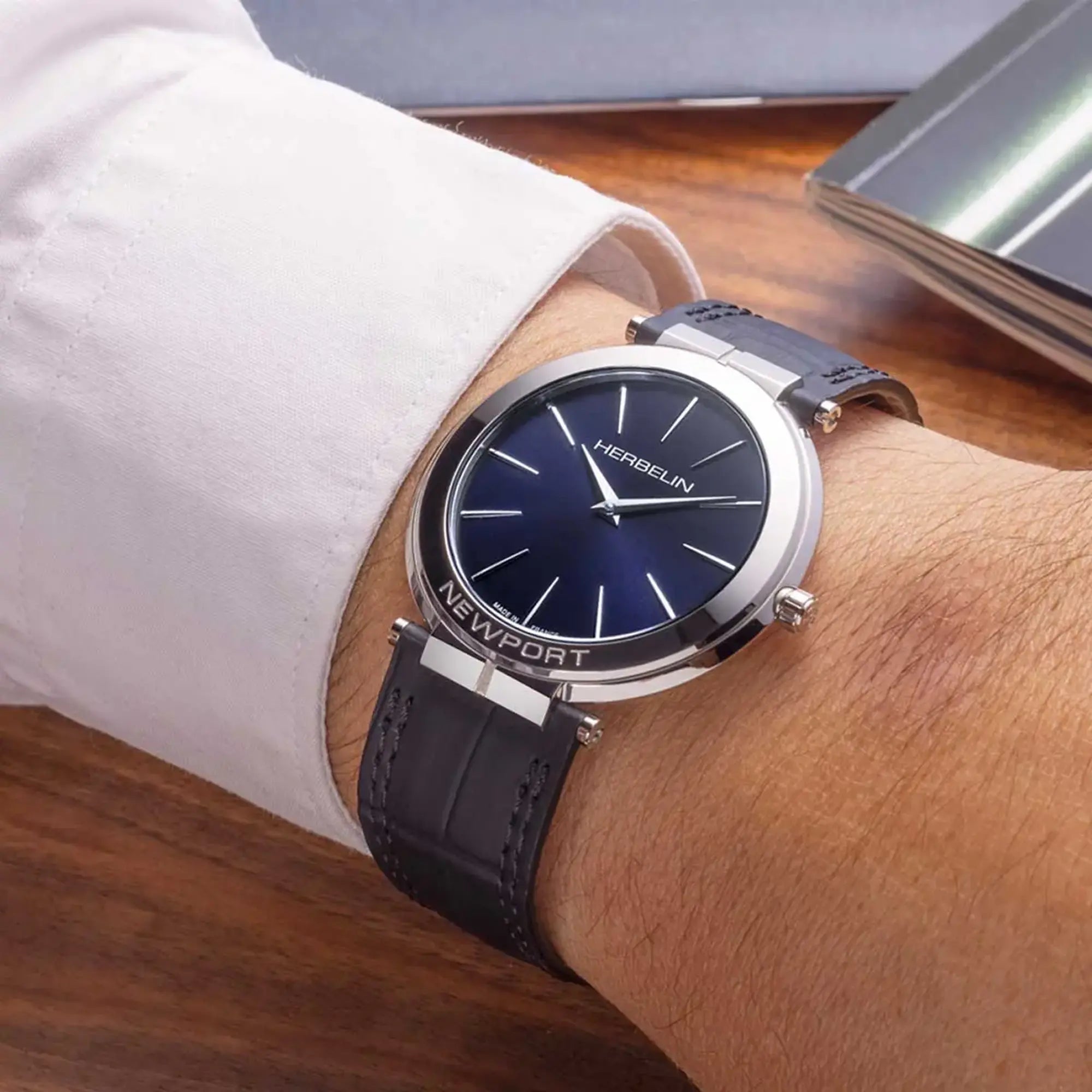 Au poignet masculin, cadran bleu profond et bracelet cuir visibles
