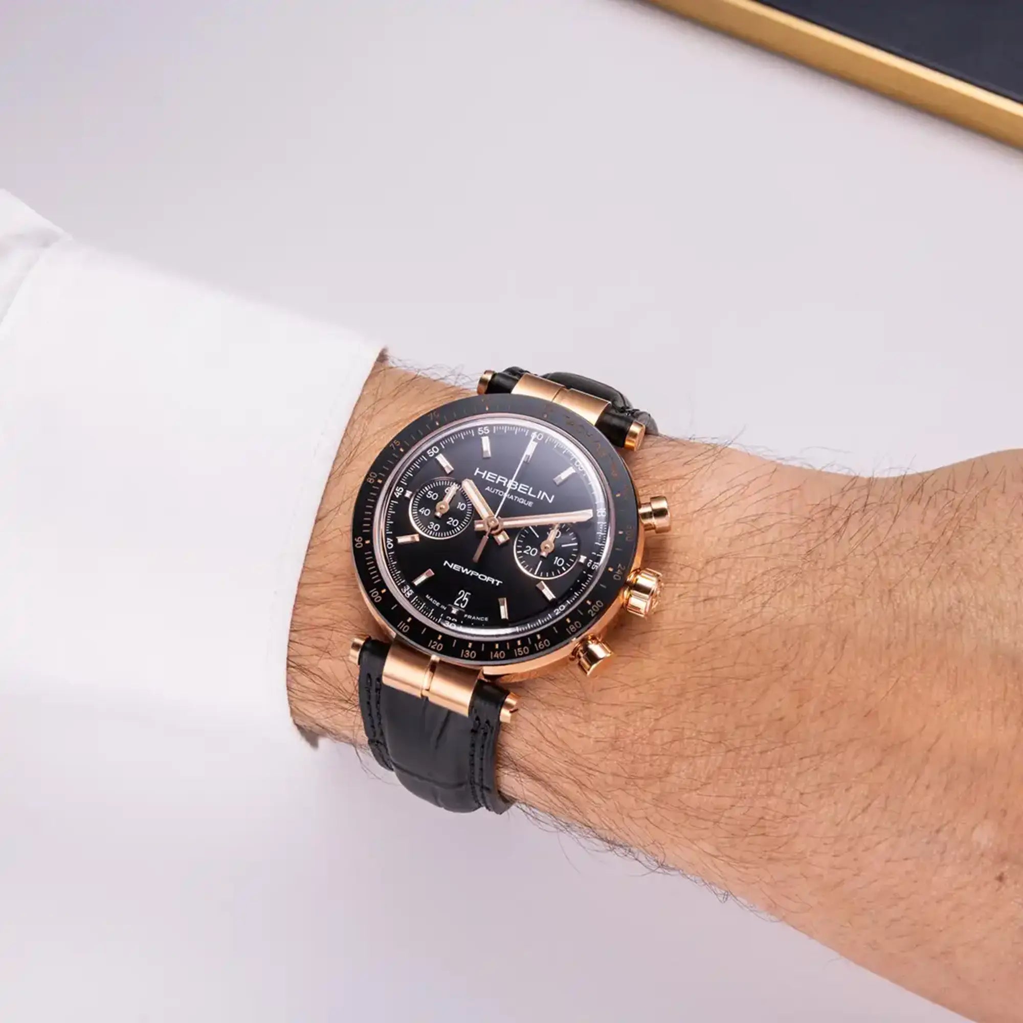 Au poignet masculin, cadran noir et bracelet cuir visibles