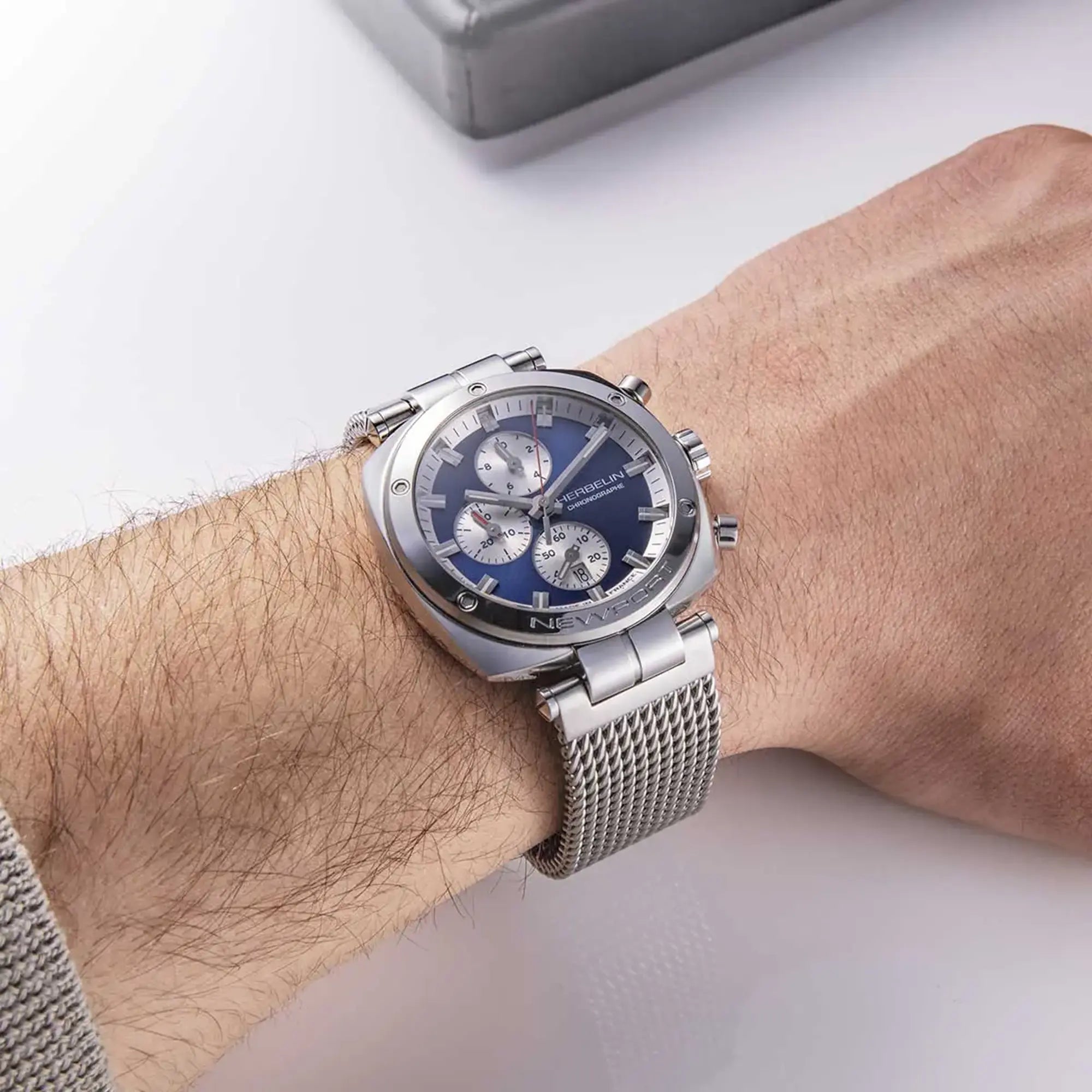 Au poignet masculin, cadran bleu et bracelet acier visibles