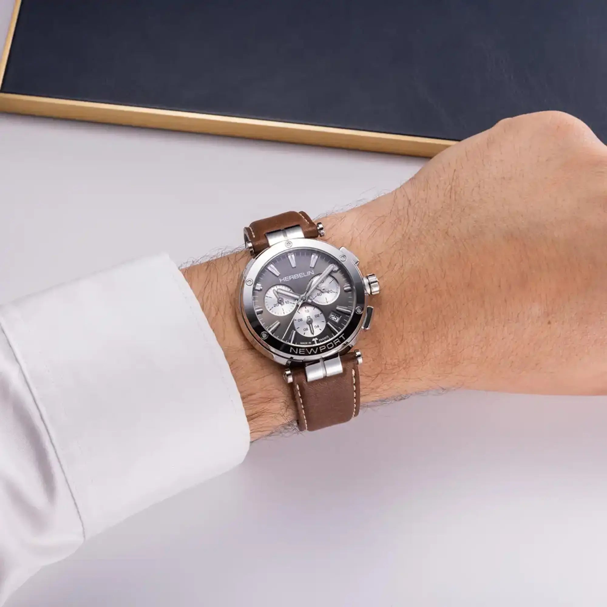 Au poignet masculin, cadran anthracite et bracelet cuir visibles