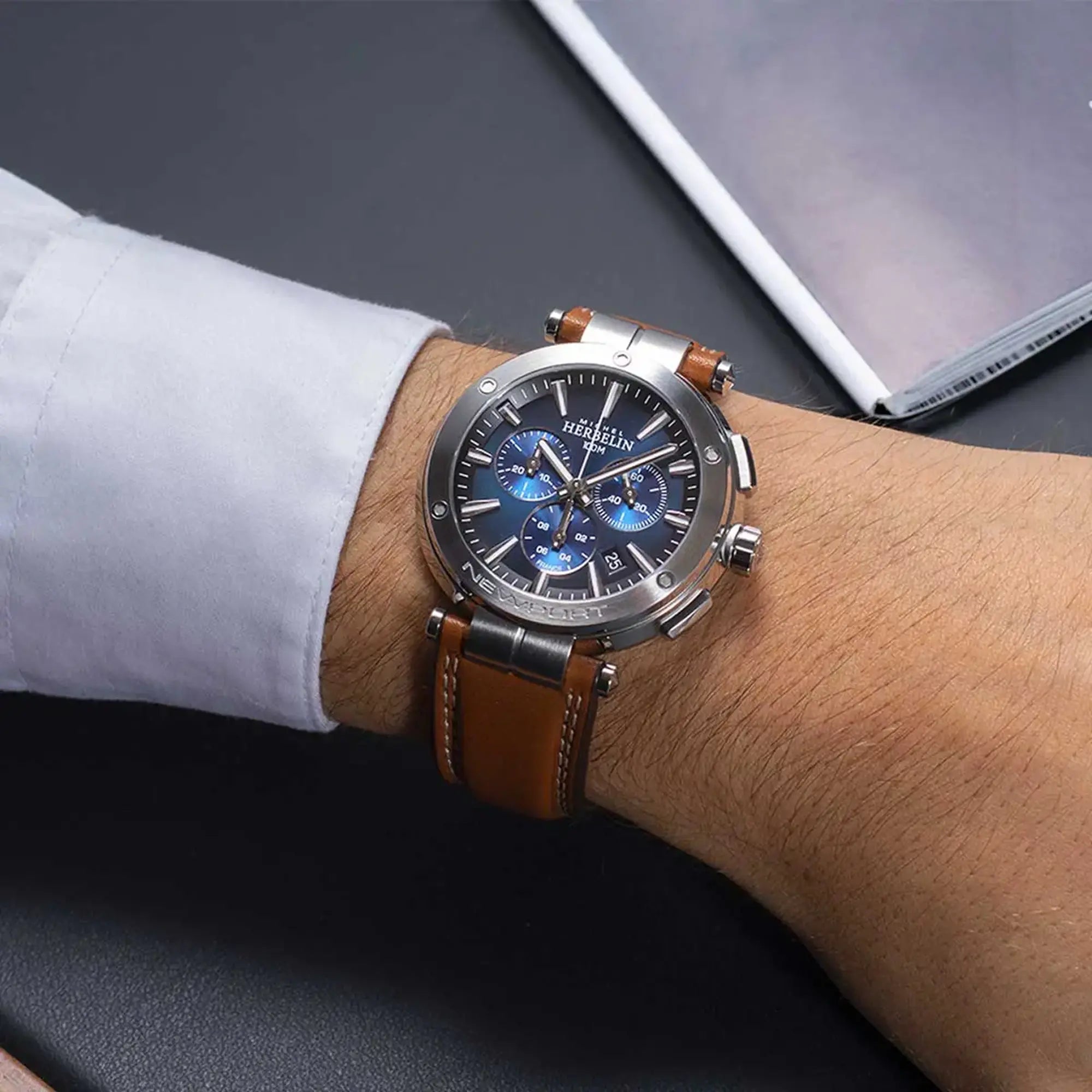 Au poignet masculin, cadran bleu dégradé et bracelet cuir visibles