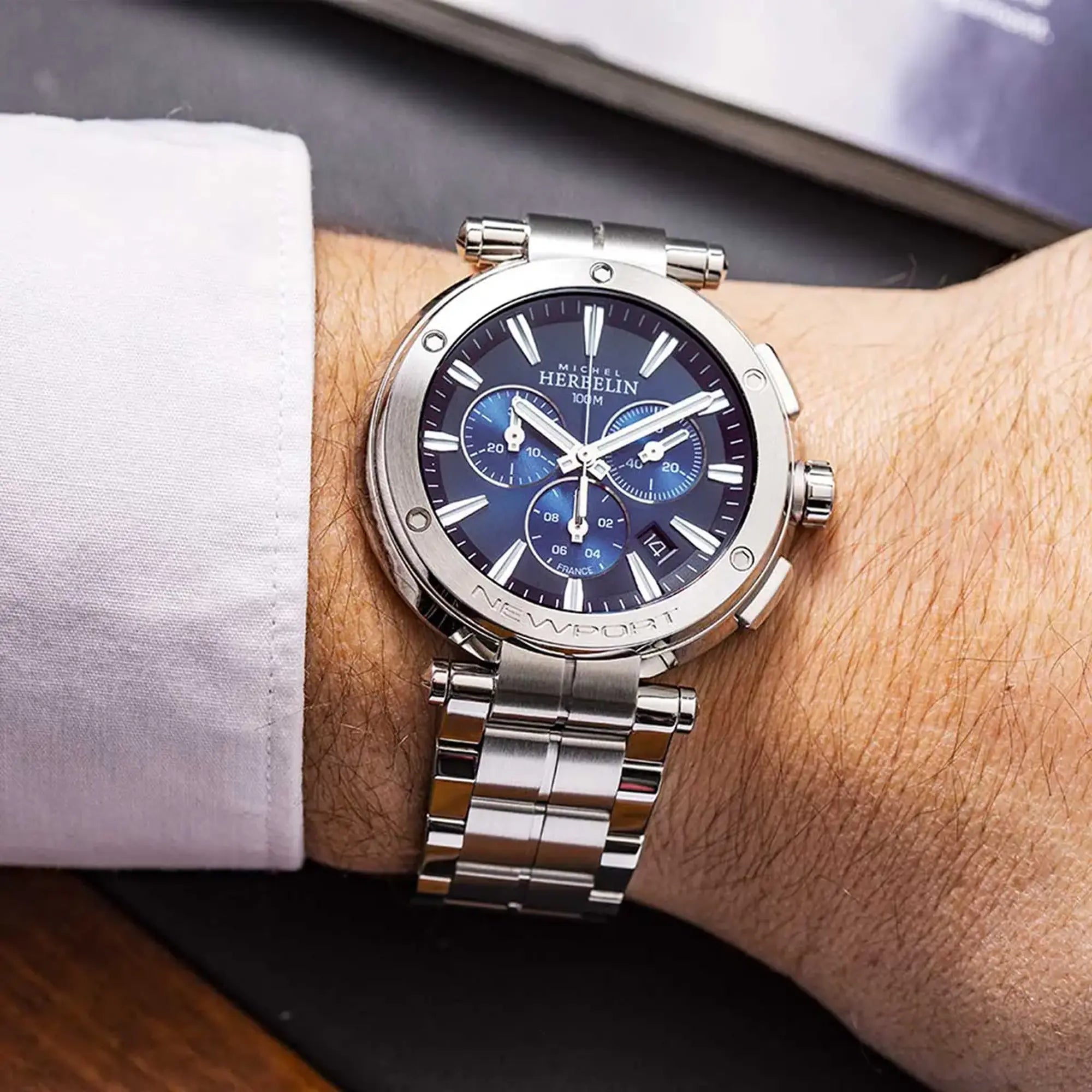 Au poignet masculin, cadran bleu dégradé et bracelet acier visibles