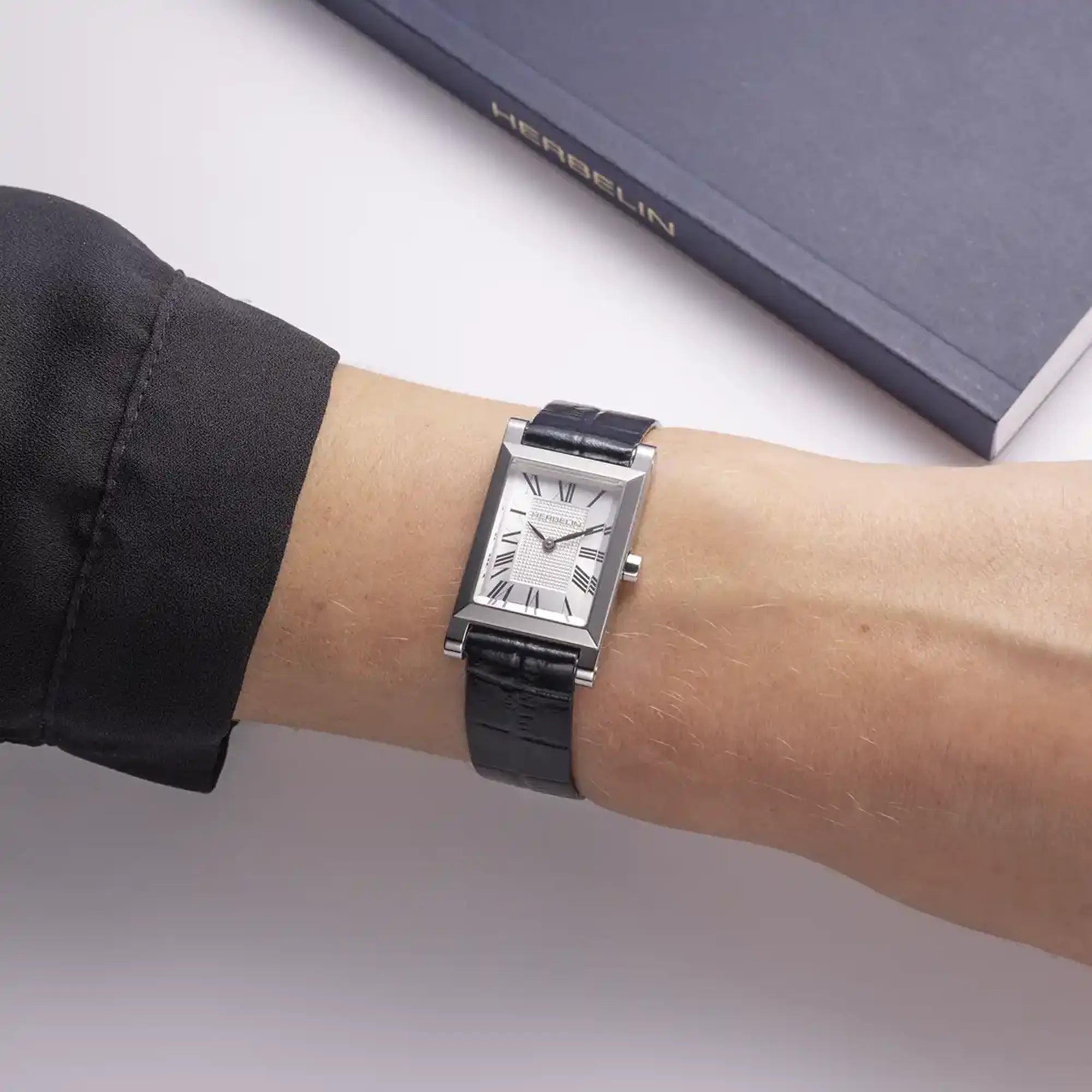 Bracelet porté au poignet féminin, cuir façon croco visible