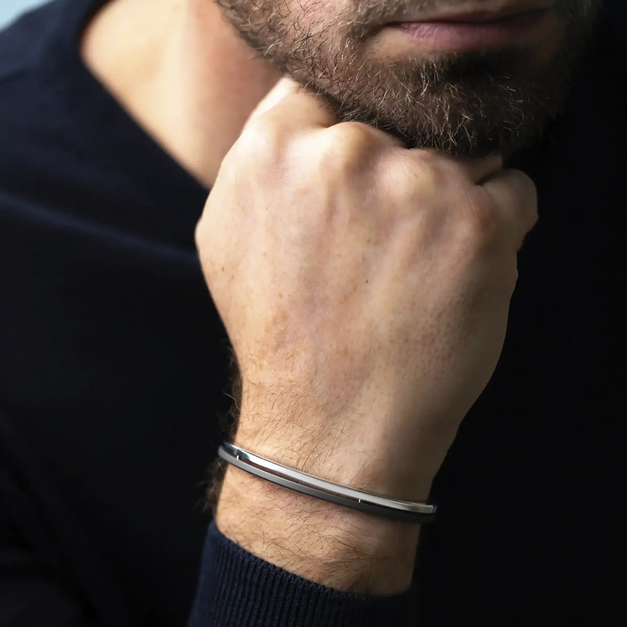 Armring båret på et mands håndled, titanium synlig