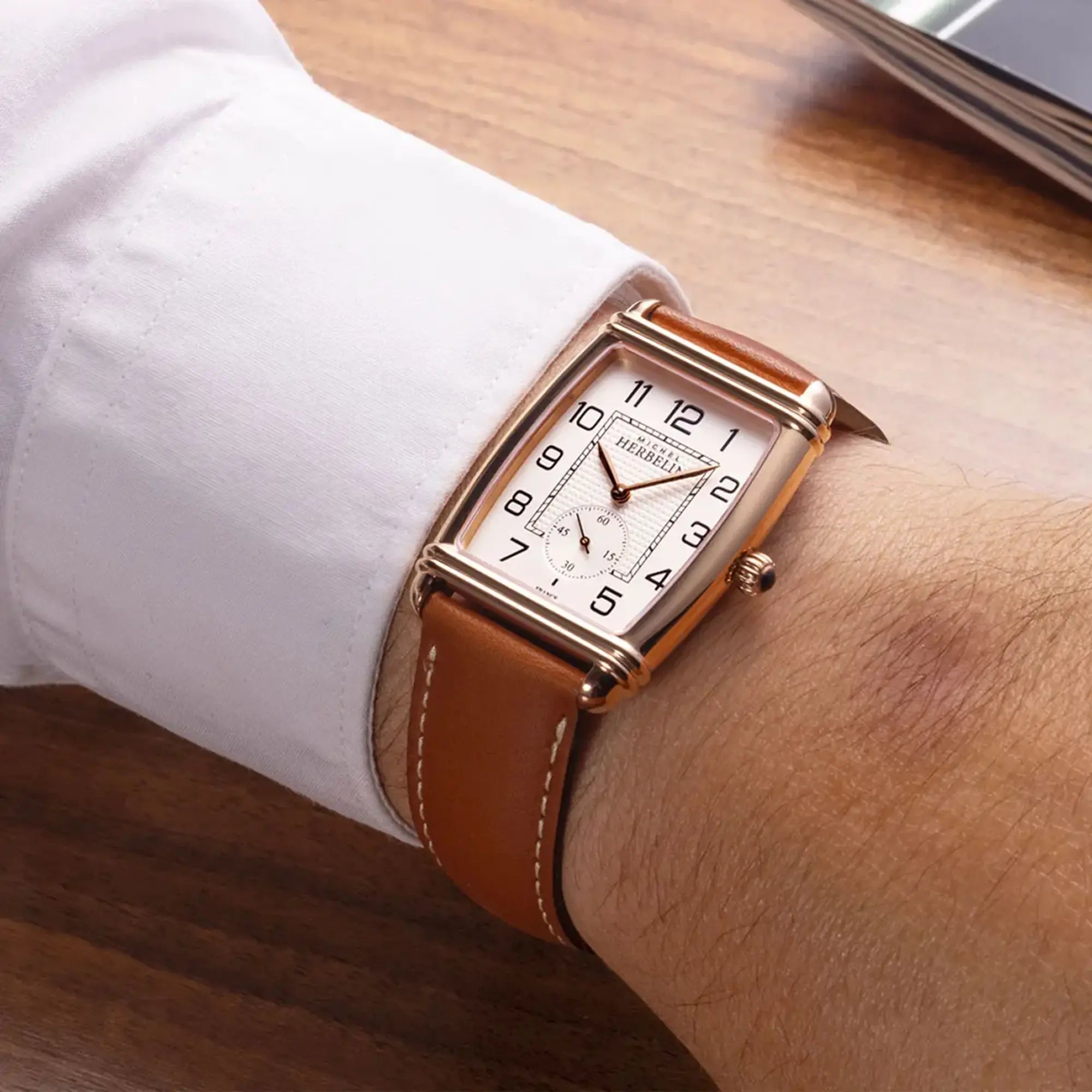 Au poignet masculin, cadran argent guilloché et bracelet cuir visibles