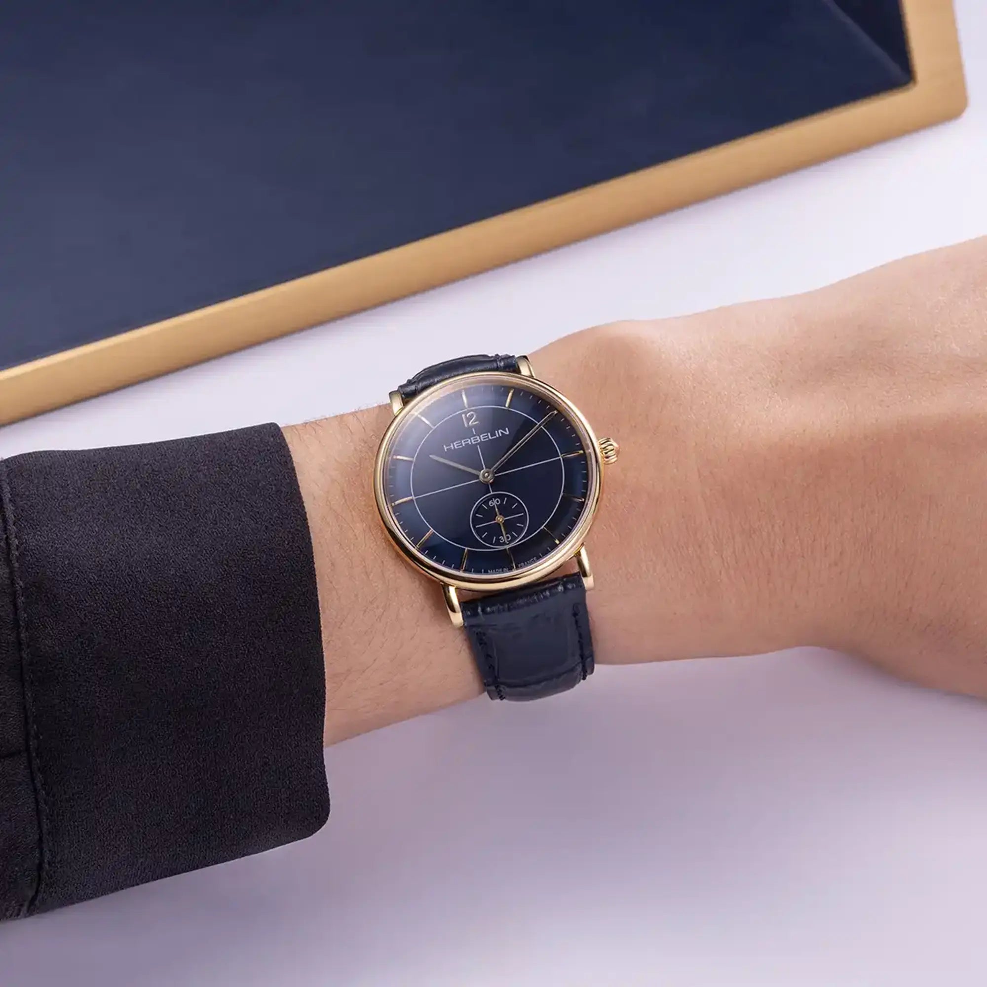 Au poignet féminin, cadran bleu et bracelet cuir visibles