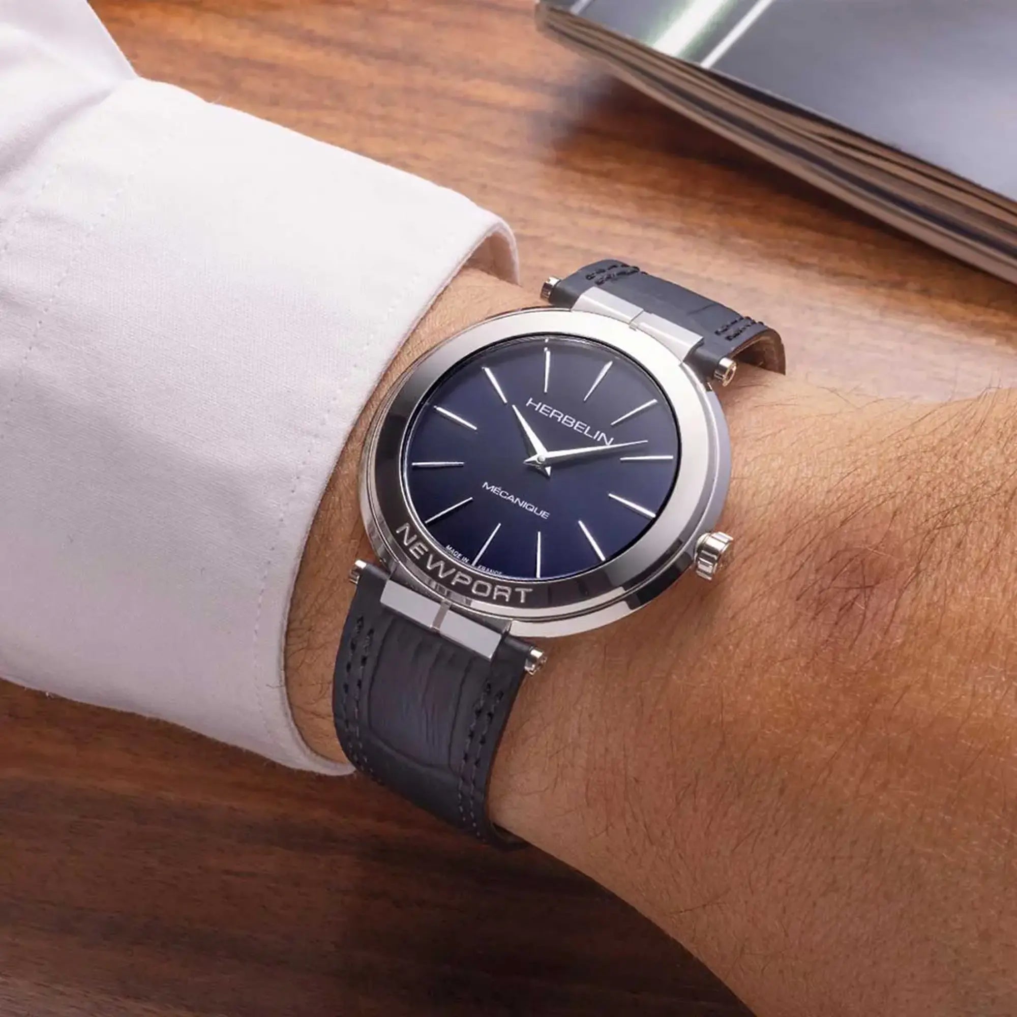 Au poignet masculin, cadran bleu profond et bracelet cuir visibles