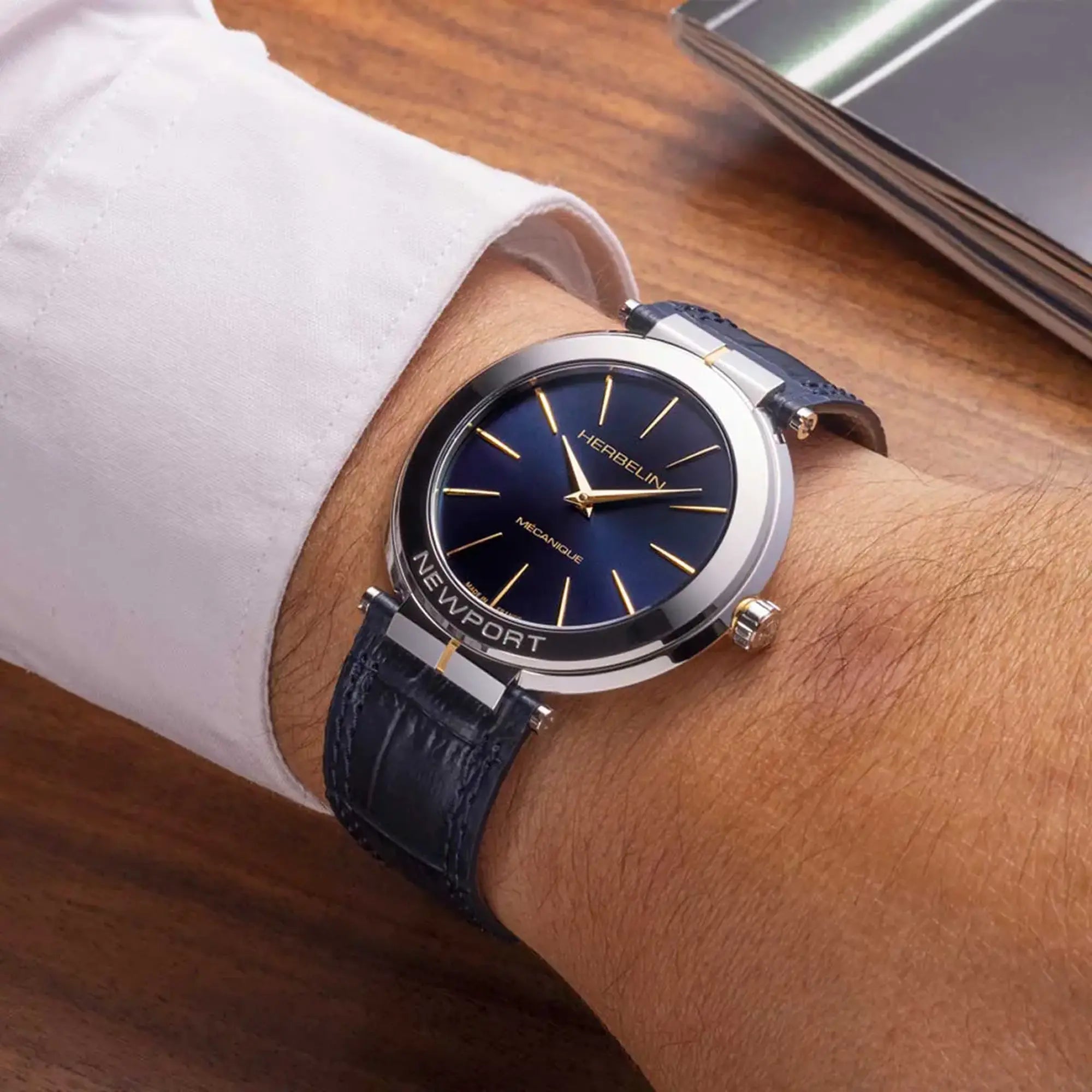 Au poignet masculin, cadran bleu profond et bracelet cuir visibles
