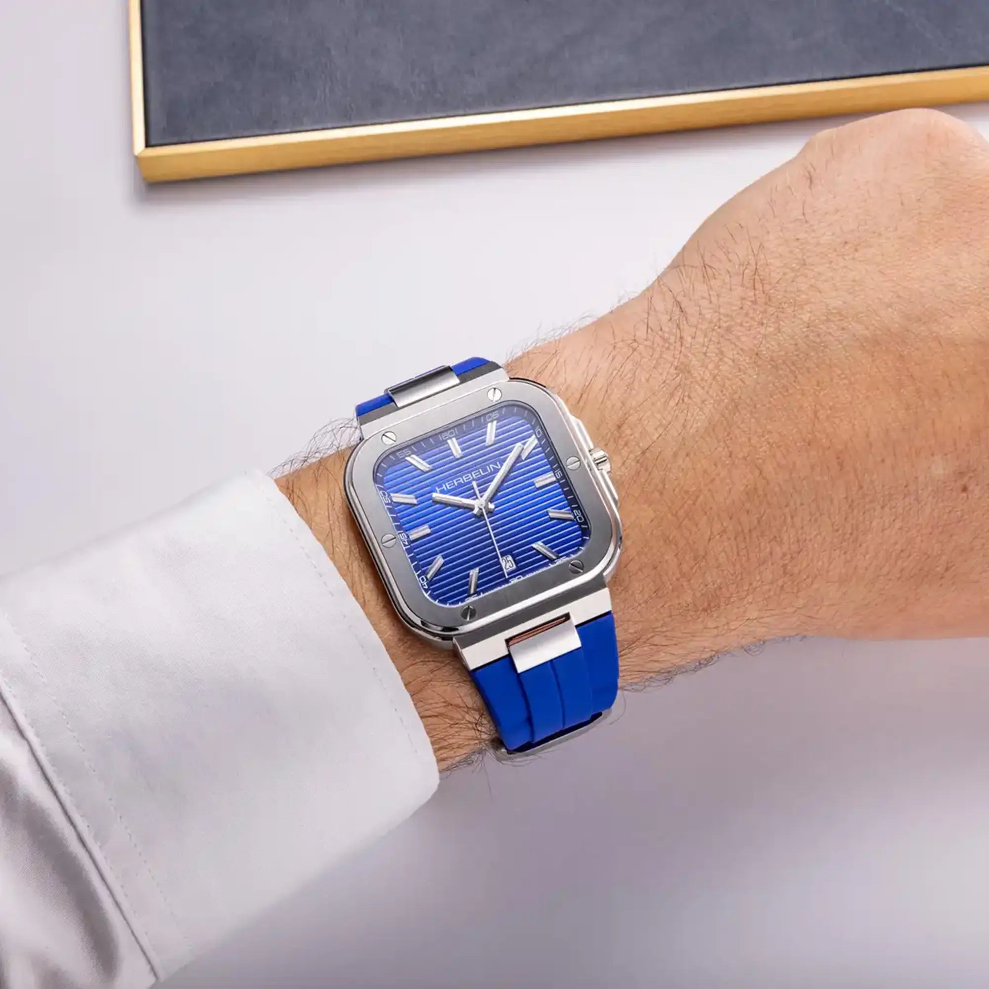 Au poignet masculin, cadran bleu cobalt et bracelet caoutchouc visibles