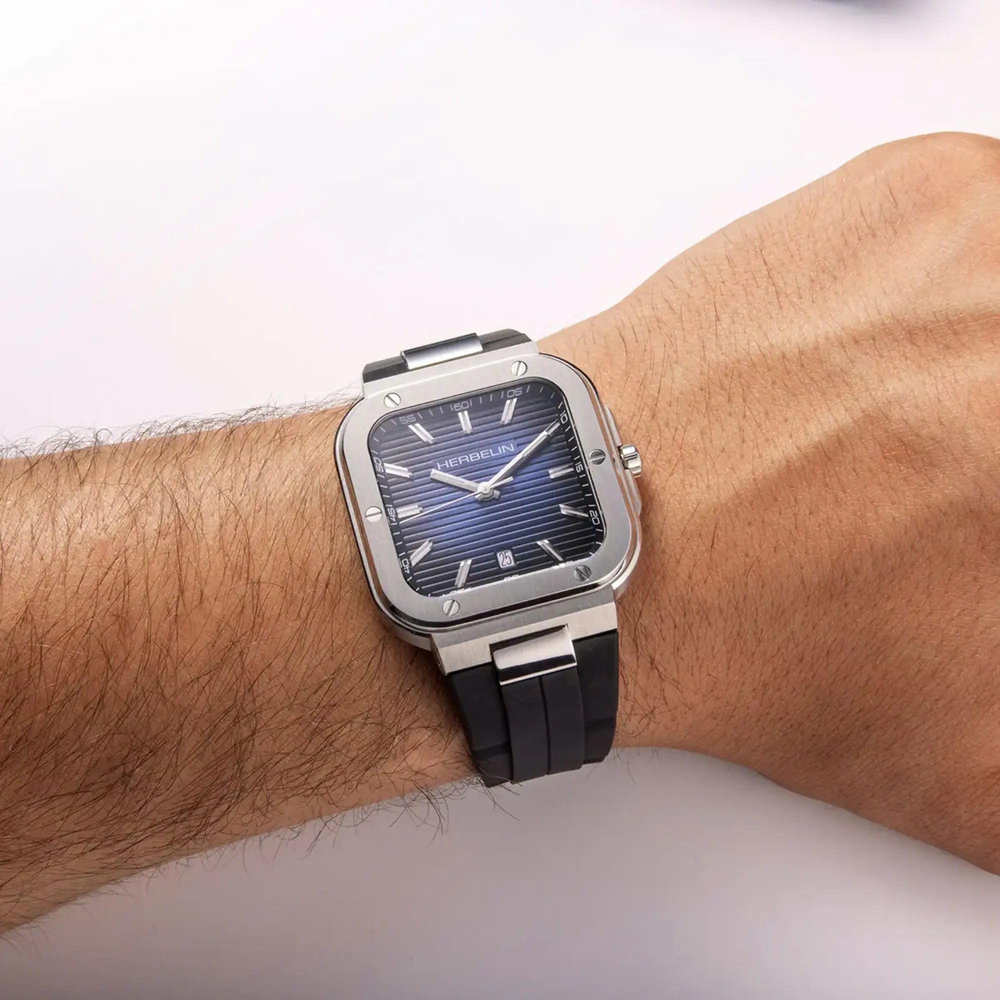 Au poignet masculin, cadran bleu dégradé et bracelet caoutchouc visibles