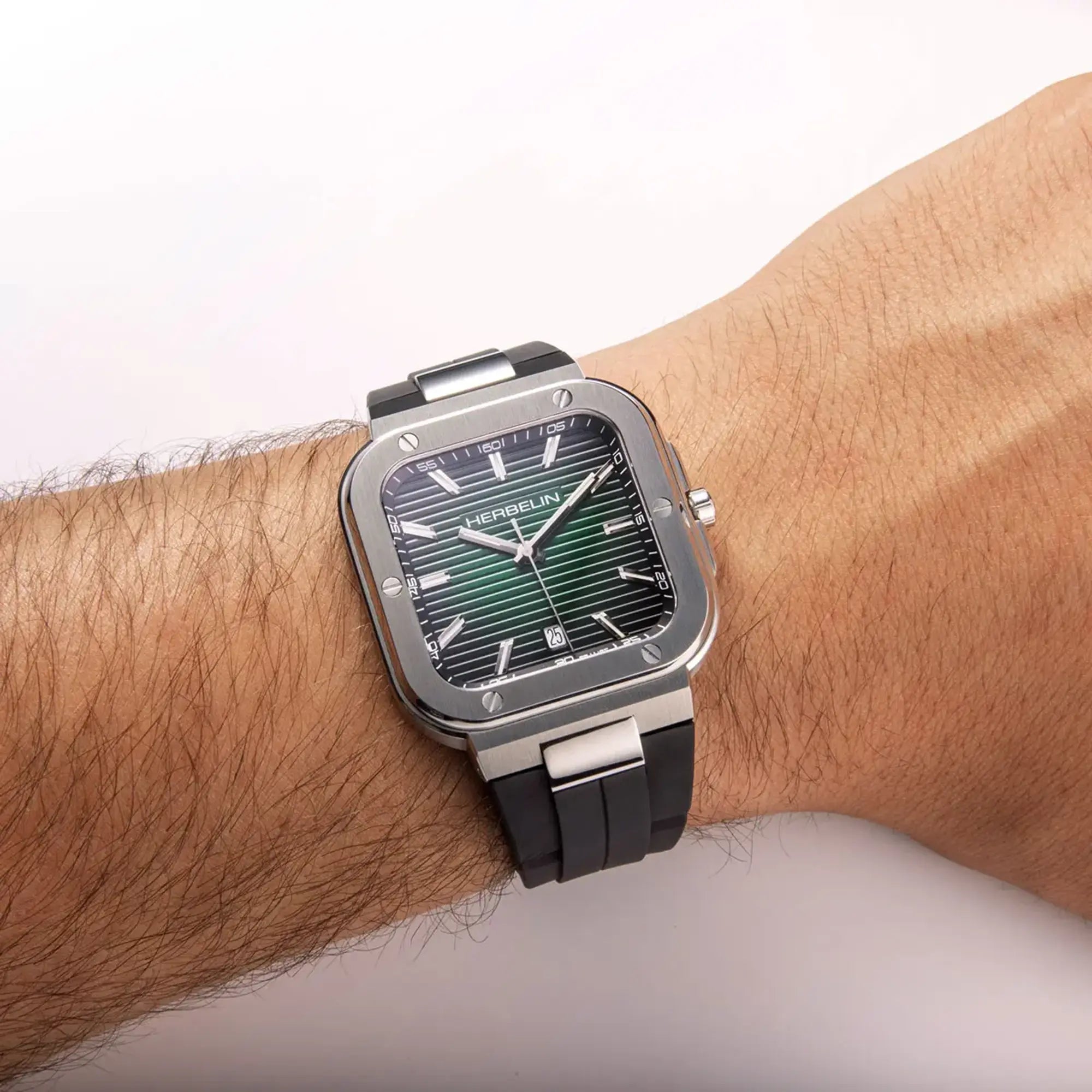 Au poignet masculin, cadran noir et bracelet caoutchouc visibles