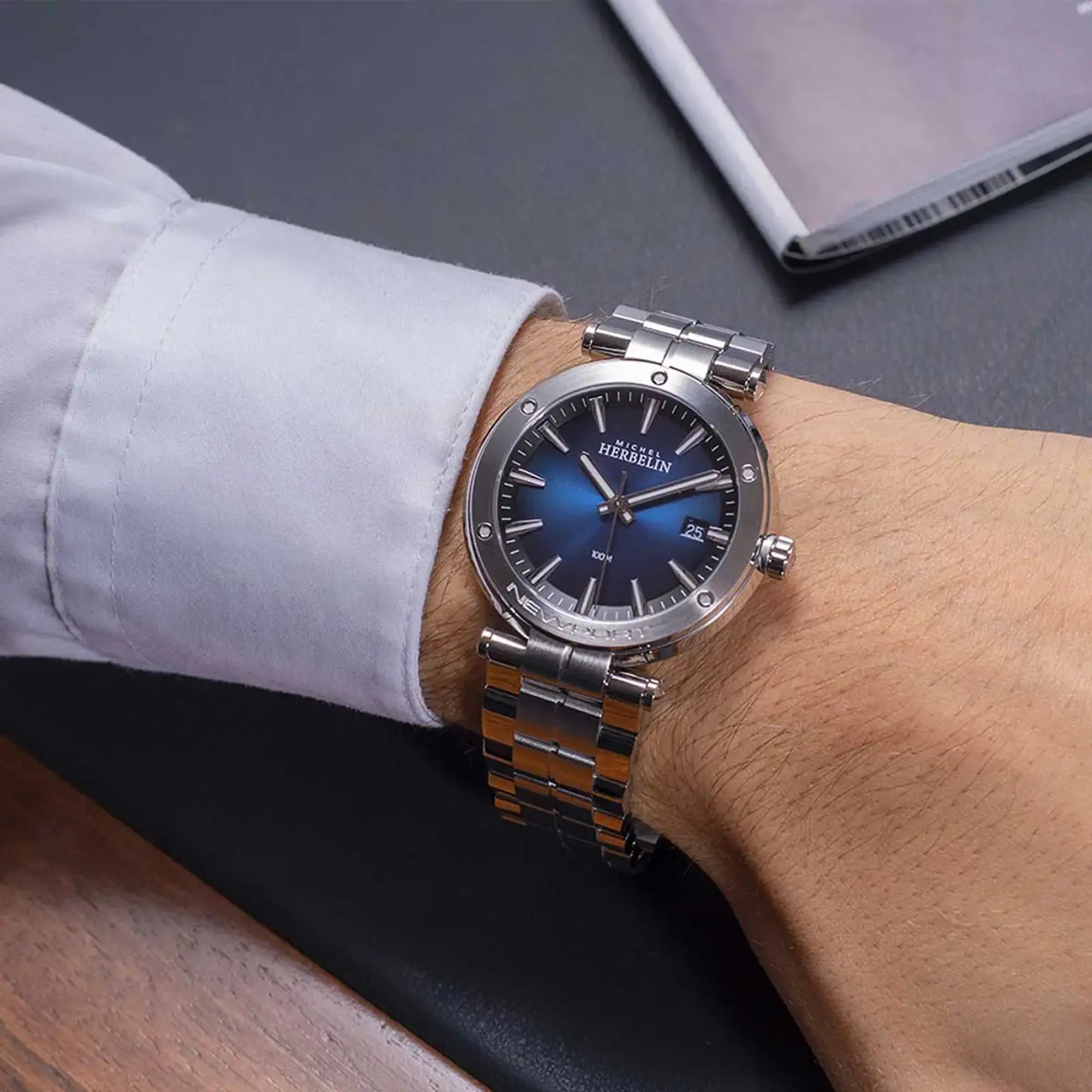Au poignet masculin, cadran bleu dégradé et bracelet acier visibles