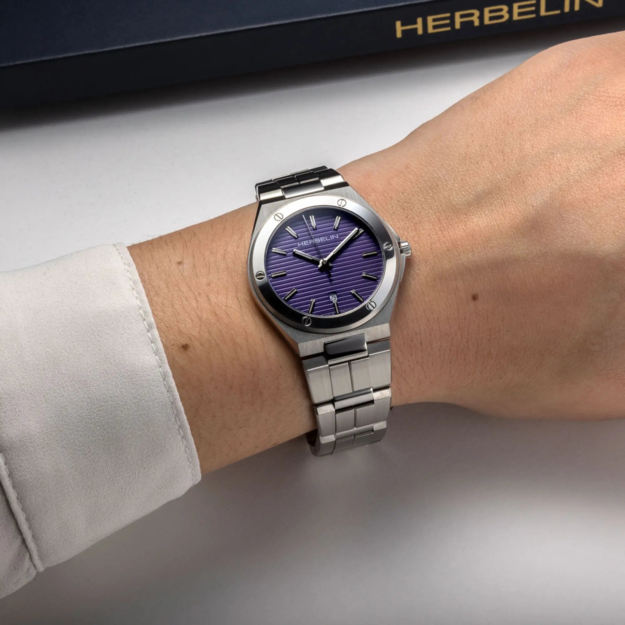 Au poignet féminin, cadran noir et bracelet acier visibles