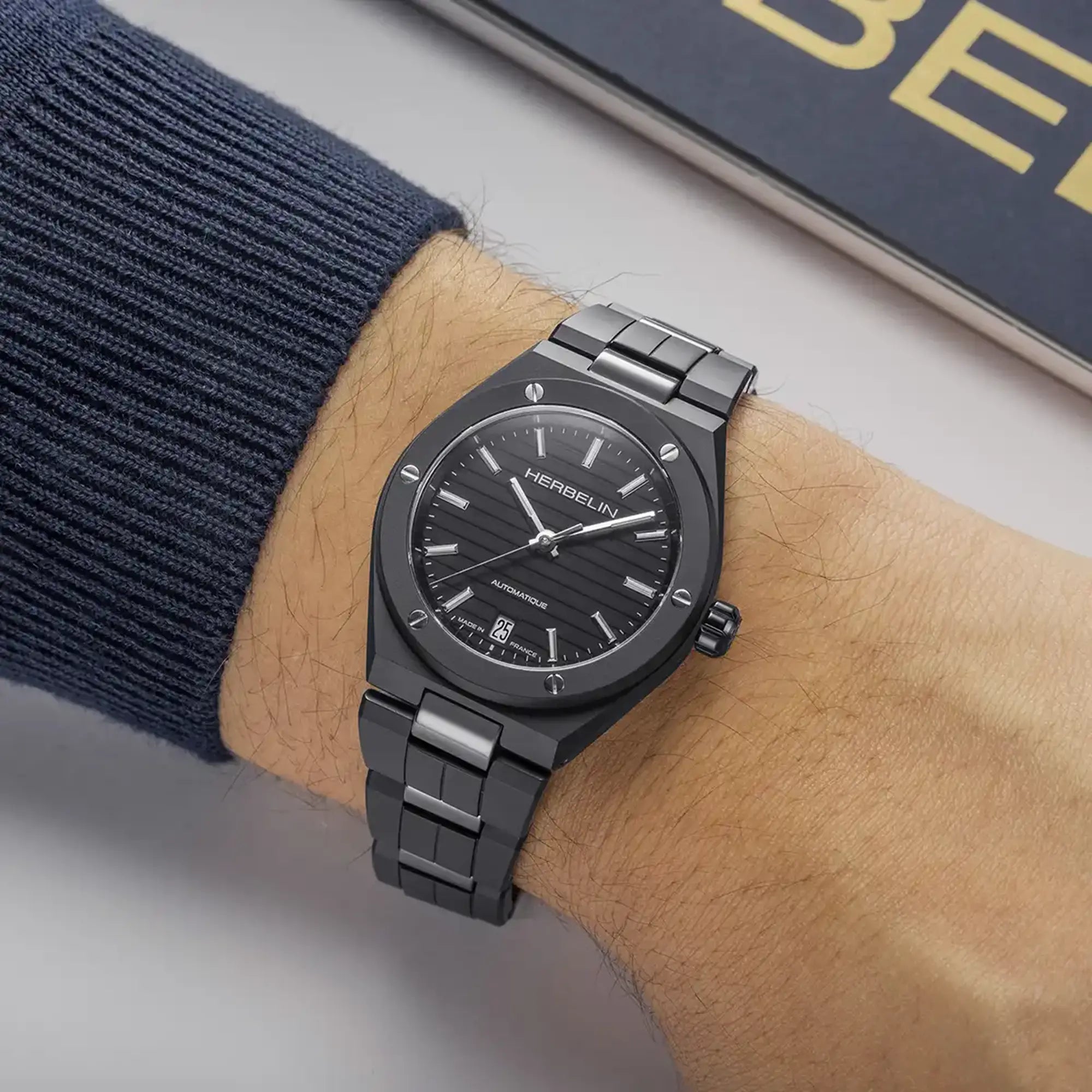 Au poignet masculin, cadran noir et bracelet céramique visibles