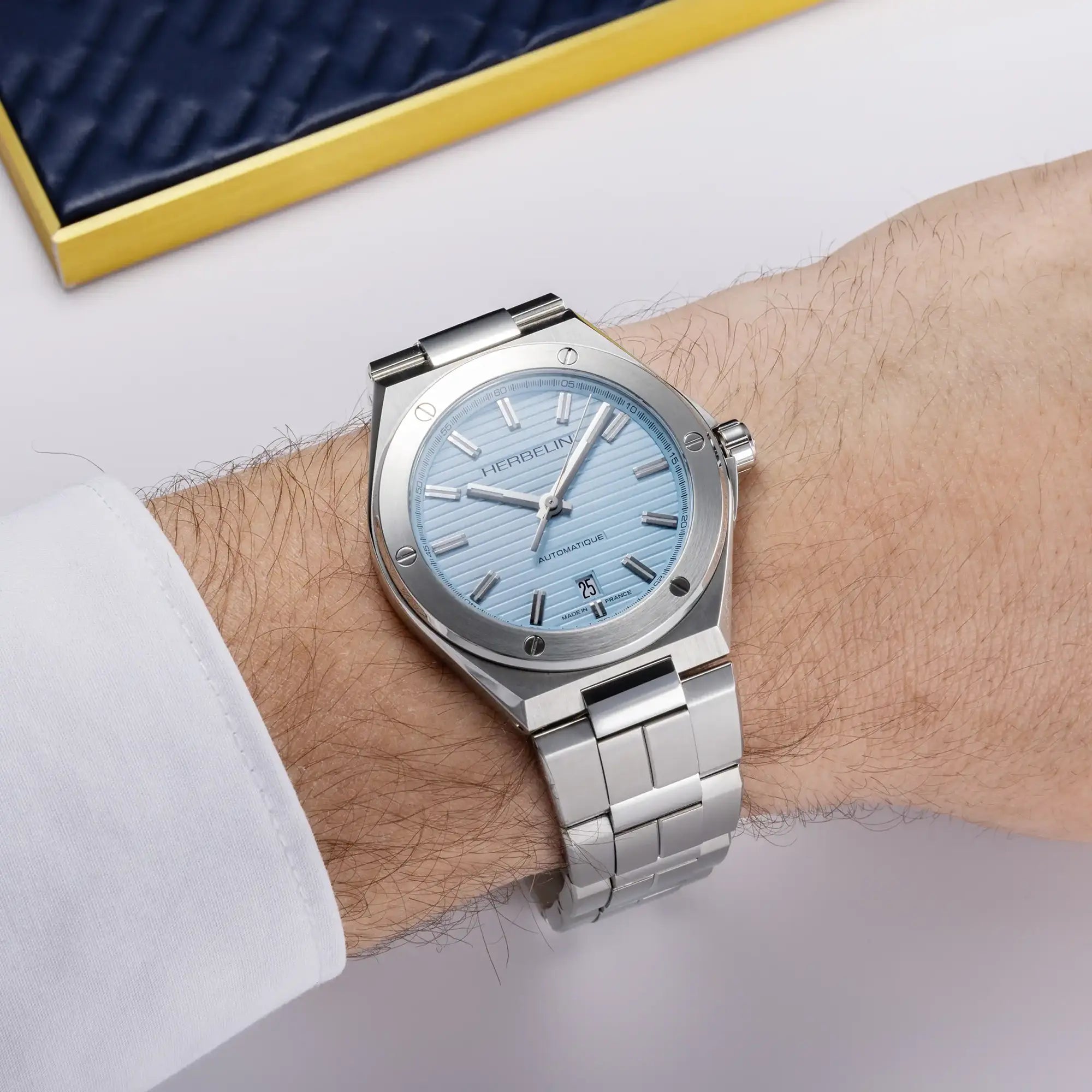 Au poignet masculin, cadran bleu arctique et bracelet acier visibles