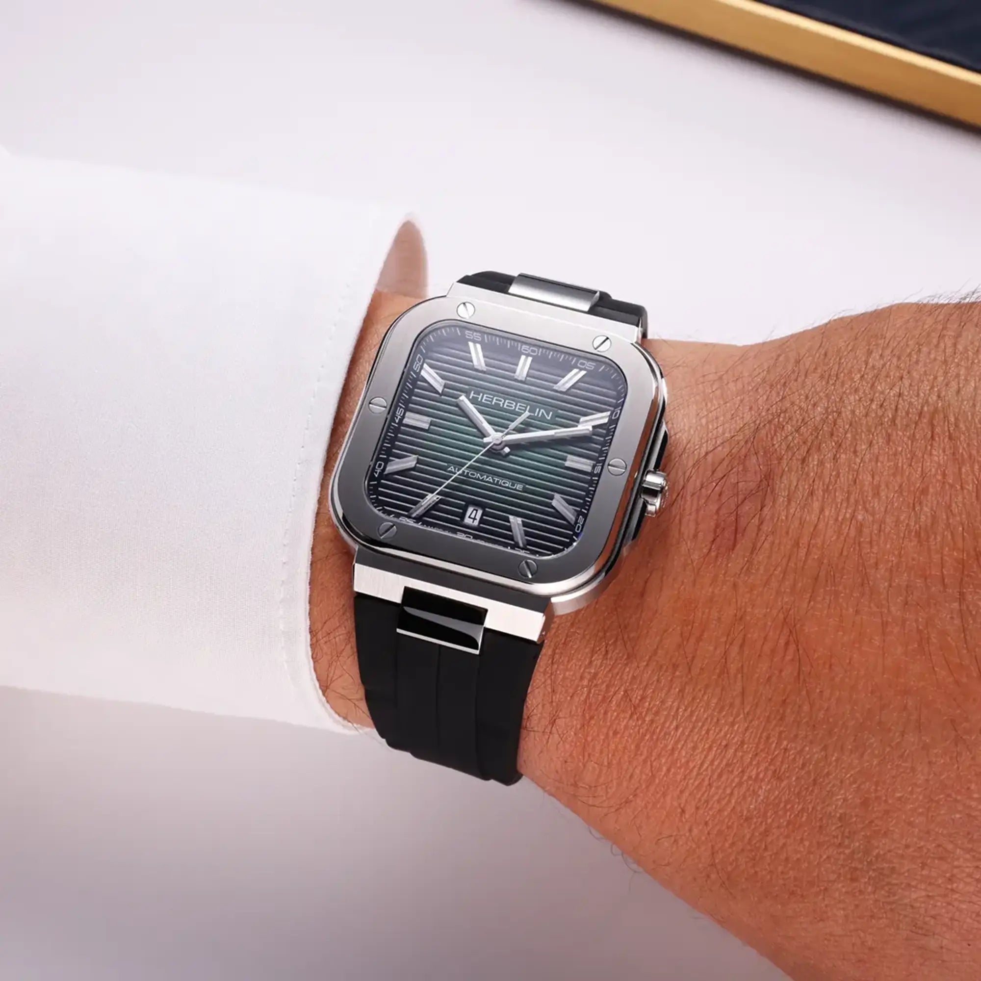 Au poignet masculin, cadran noir et bracelet caoutchouc visibles