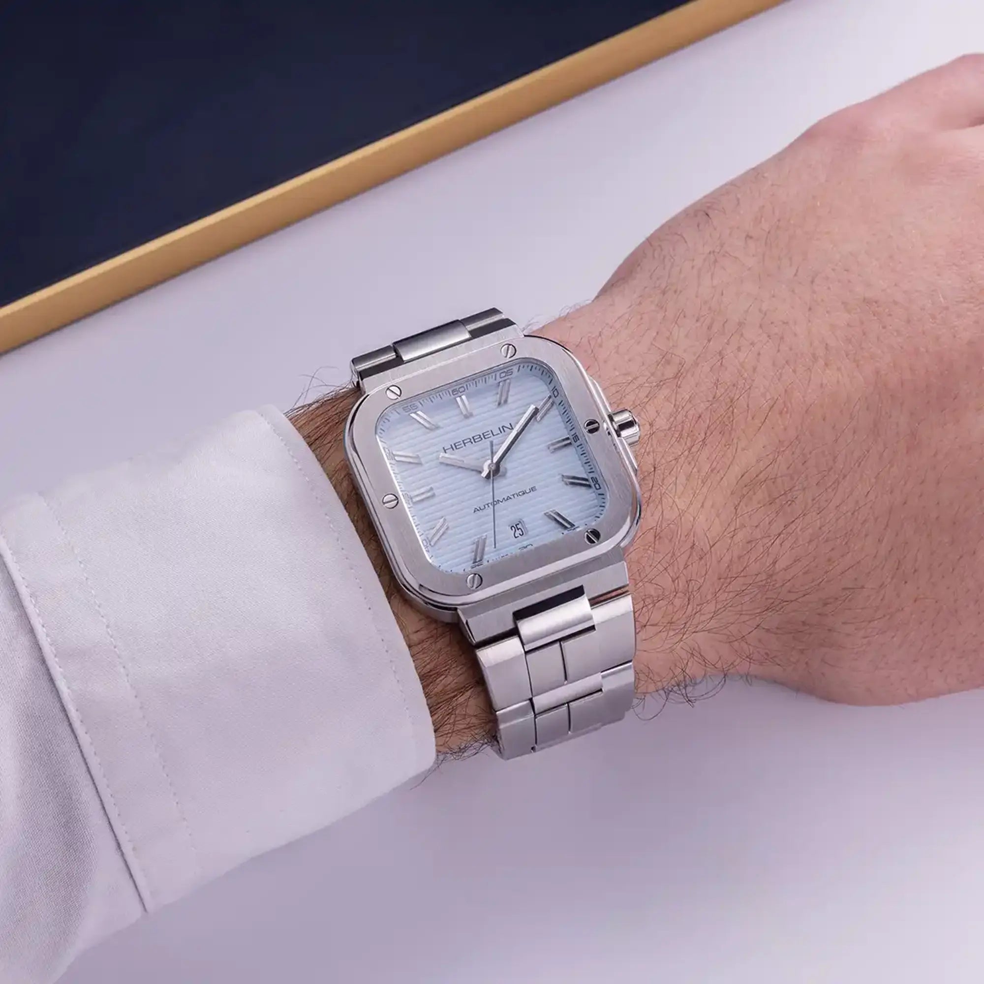Au poignet masculin, cadran bleu arctique et bracelet acier visibles