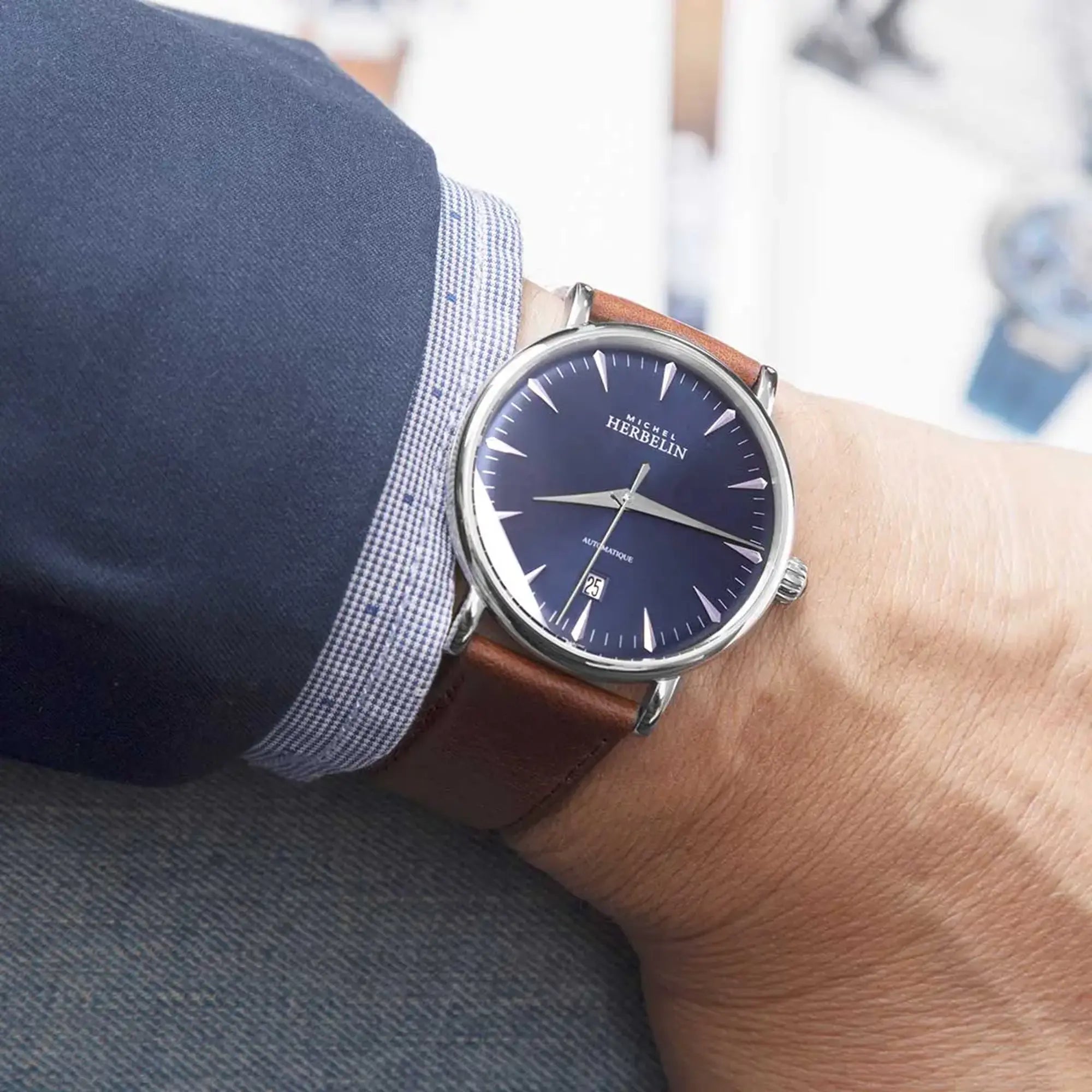 Au poignet masculin, cadran bleu et bracelet cuir visibles