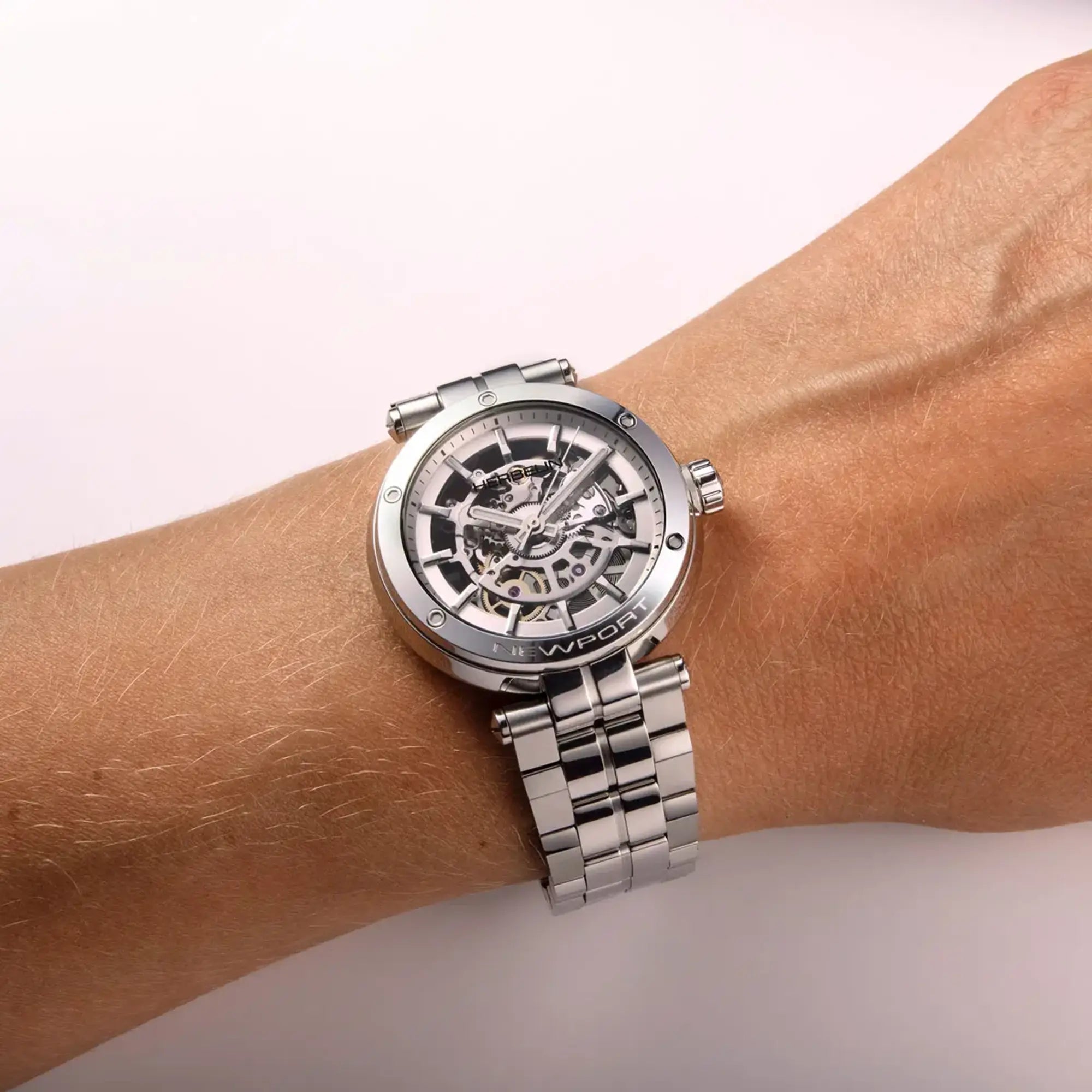 Au poignet féminin, cadran argent et bracelet acier visibles