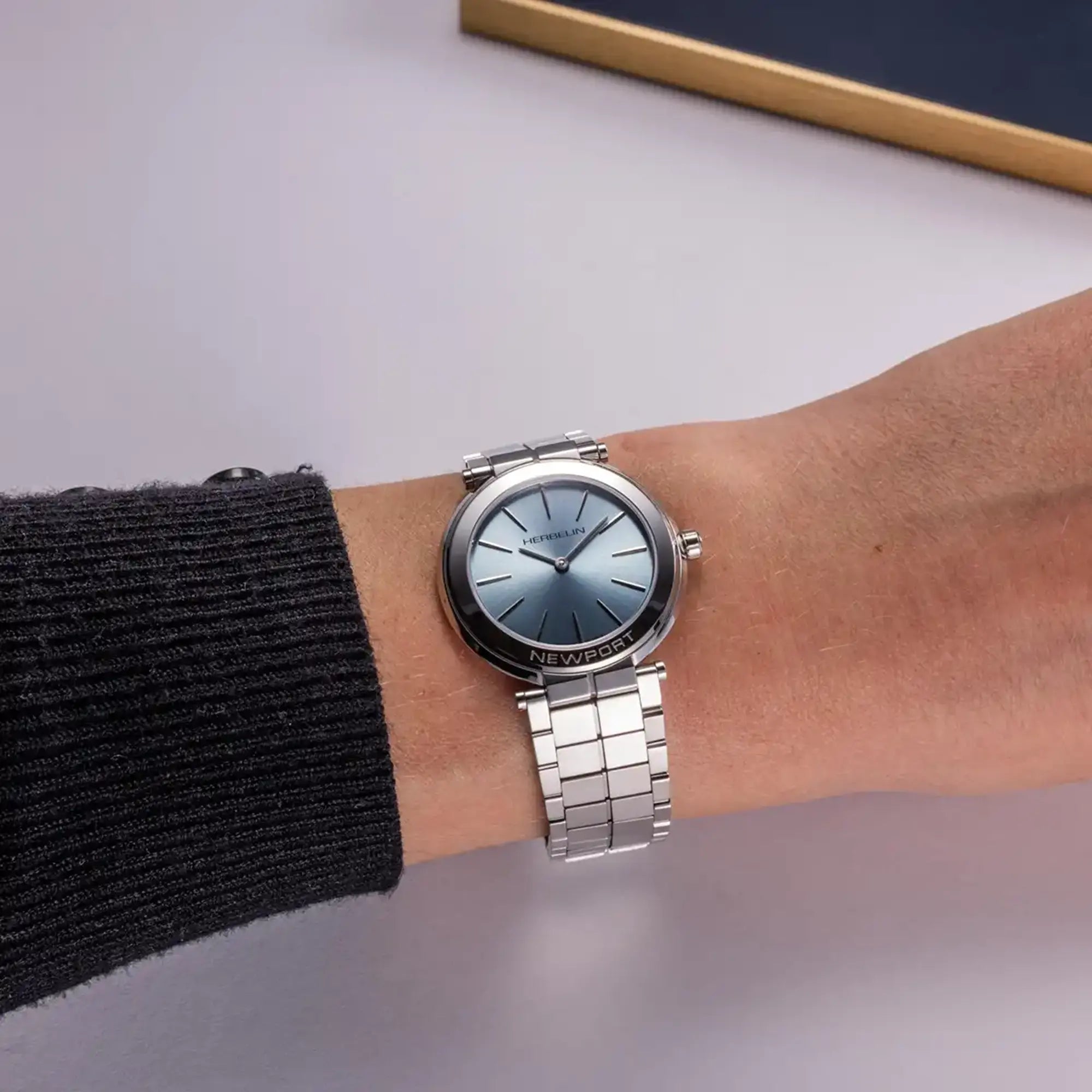 Au poignet féminin, cadran bleu arctique et bracelet acier visibles