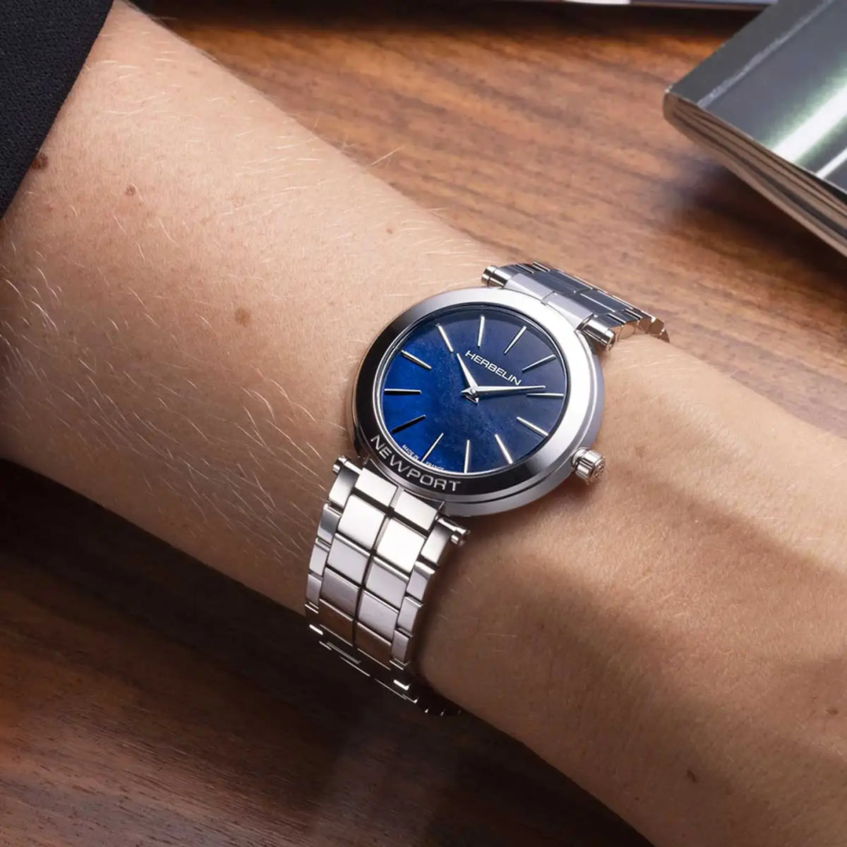 ⁣⁢Al polso femminile, quadrante nacre bleue e bracciale in acciaio visibili⁤⁣