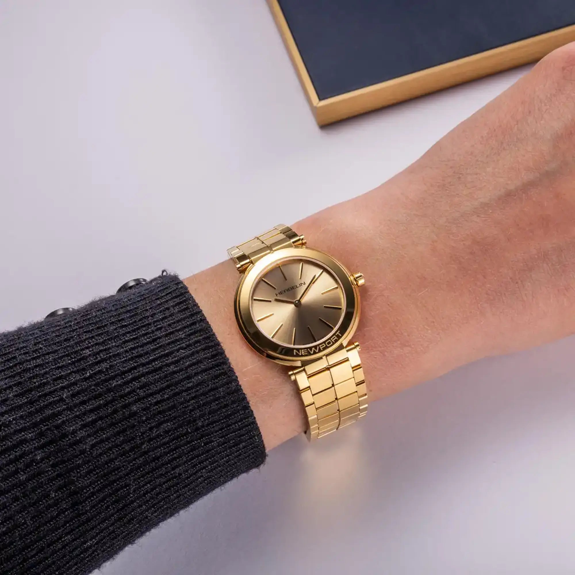 Au poignet féminin, cadran champagne et bracelet acier bicolore visibles