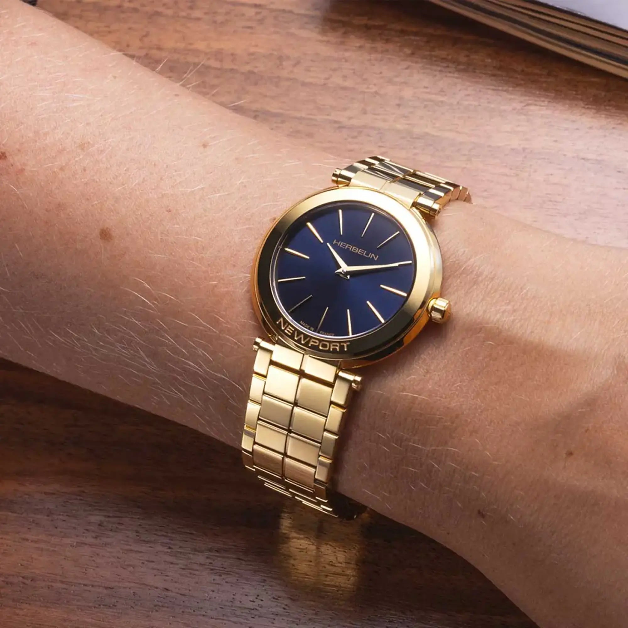 Au poignet féminin, cadran bleu profond et bracelet acier bicolore visibles