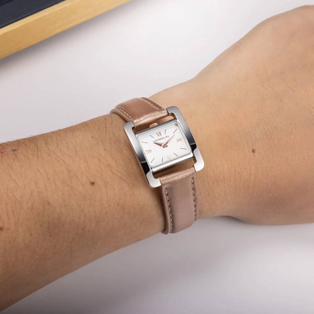 ⁣⁢Al polso femminile, quadrante bianco laccato e bracciale in pelle visibili⁤⁣