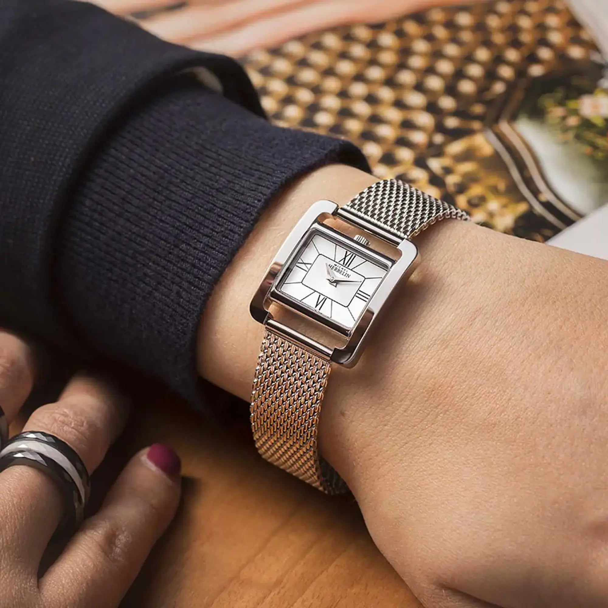 Au poignet féminin, cadran argent et bracelet acier visibles