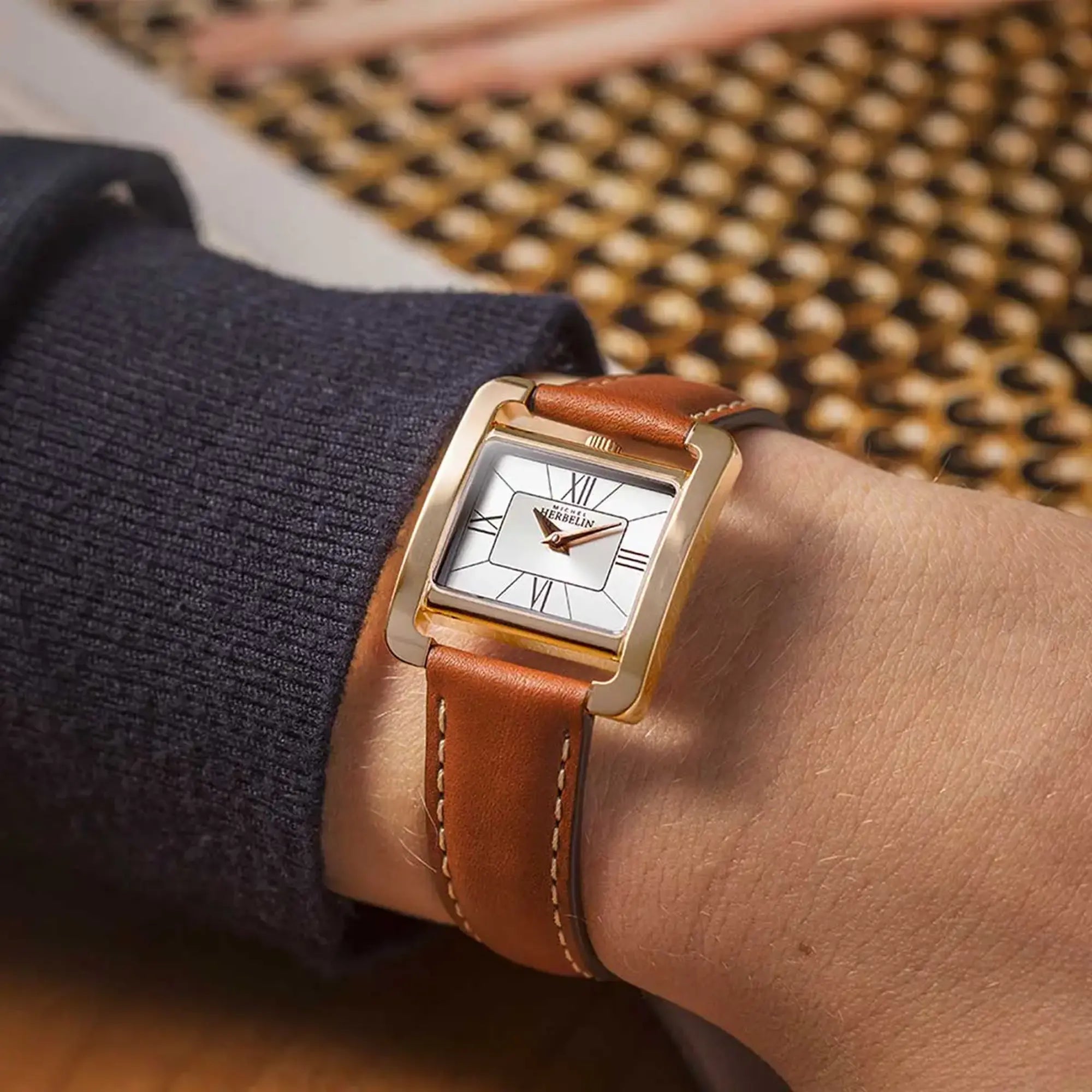Au poignet féminin, cadran argent et bracelet cuir visibles
