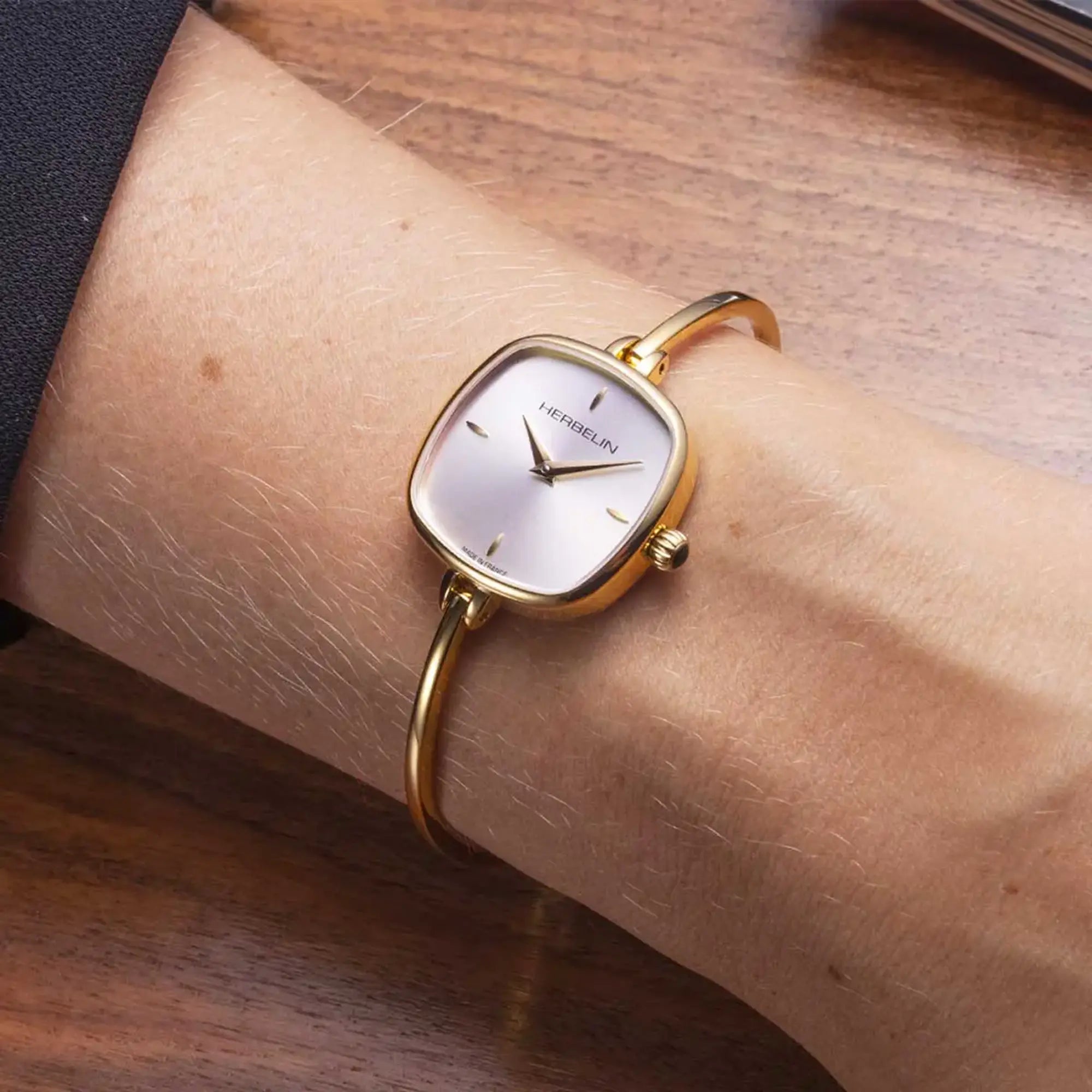 Au poignet féminin, cadran argent blanc et bracelet acier bicolore visibles