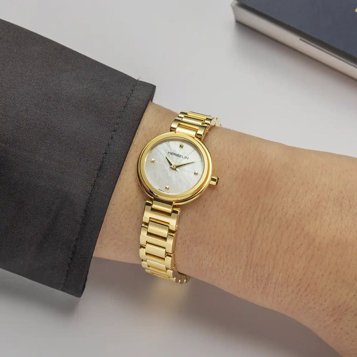 ⁣⁢En la muñeca femenina, esfera nácar blanco y brazalete de acero bicolor visibles⁤⁣