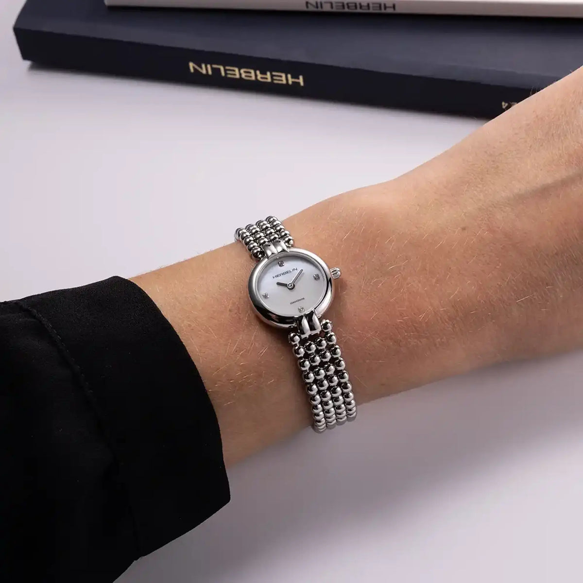 ⁣⁢For the feminine wrist, white mother-of-pearl dial and two-tone steel bracelet visible⁤⁣