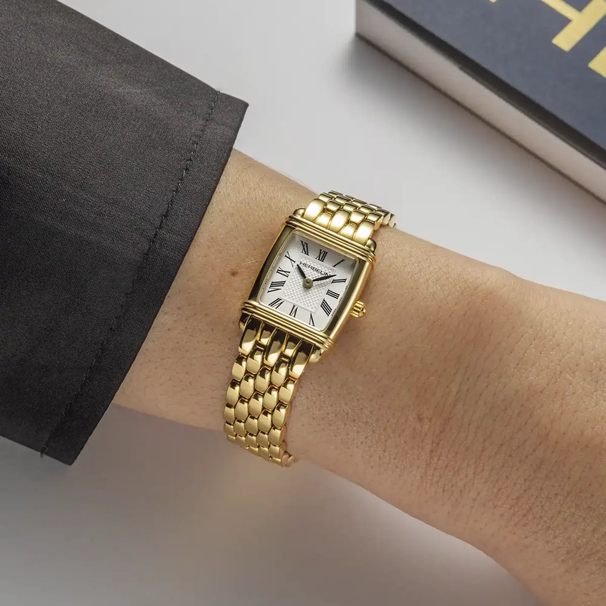 Au poignet féminin, cadran argent blanc et bracelet acier bicolore visibles