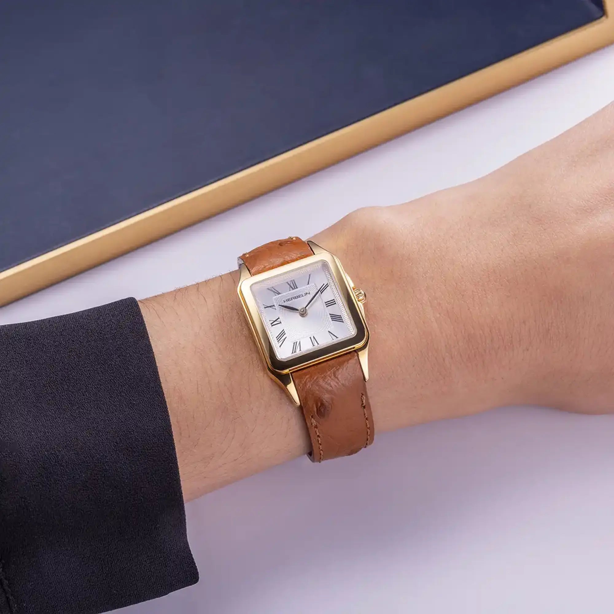 Au poignet féminin, cadran argent guilloché et bracelet cuir visibles