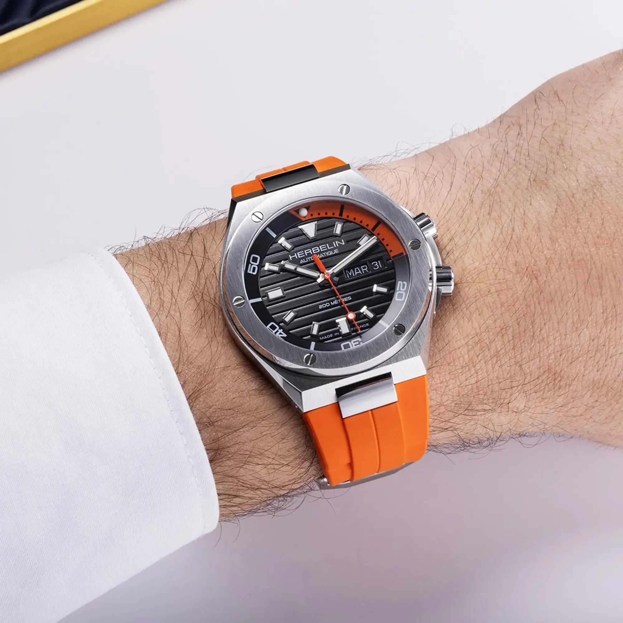 Au poignet masculin, cadran noir et bracelet caoutchouc visibles