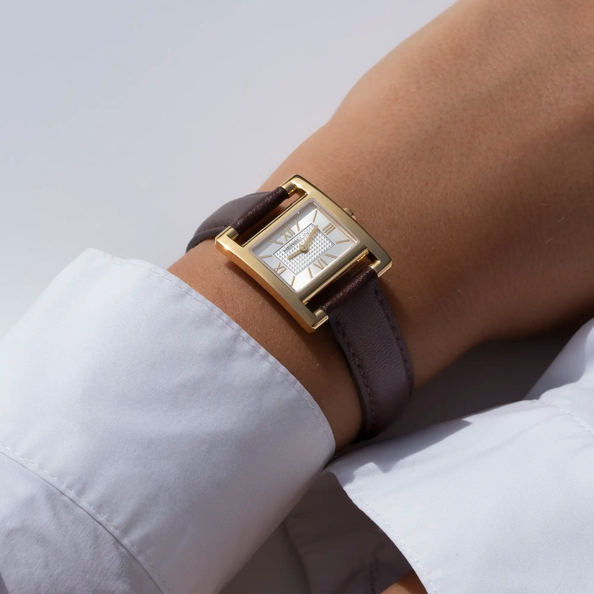 ⁣⁢Otra perspectiva en muñeca femenina, esfera plateada blanca guilloché y brazalete de piel visibles⁤⁣