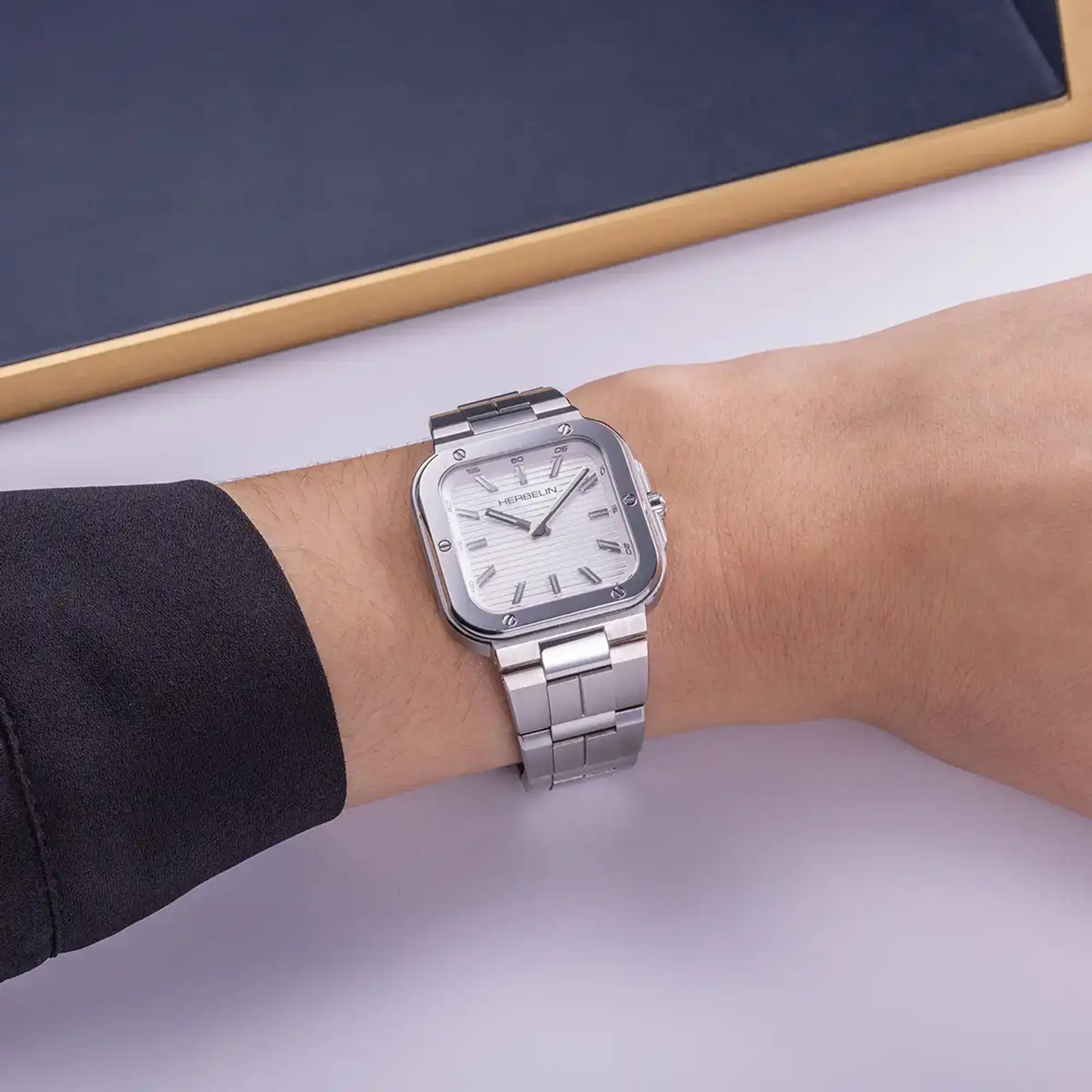 Au poignet féminin, cadran argent blanc et bracelet acier visibles